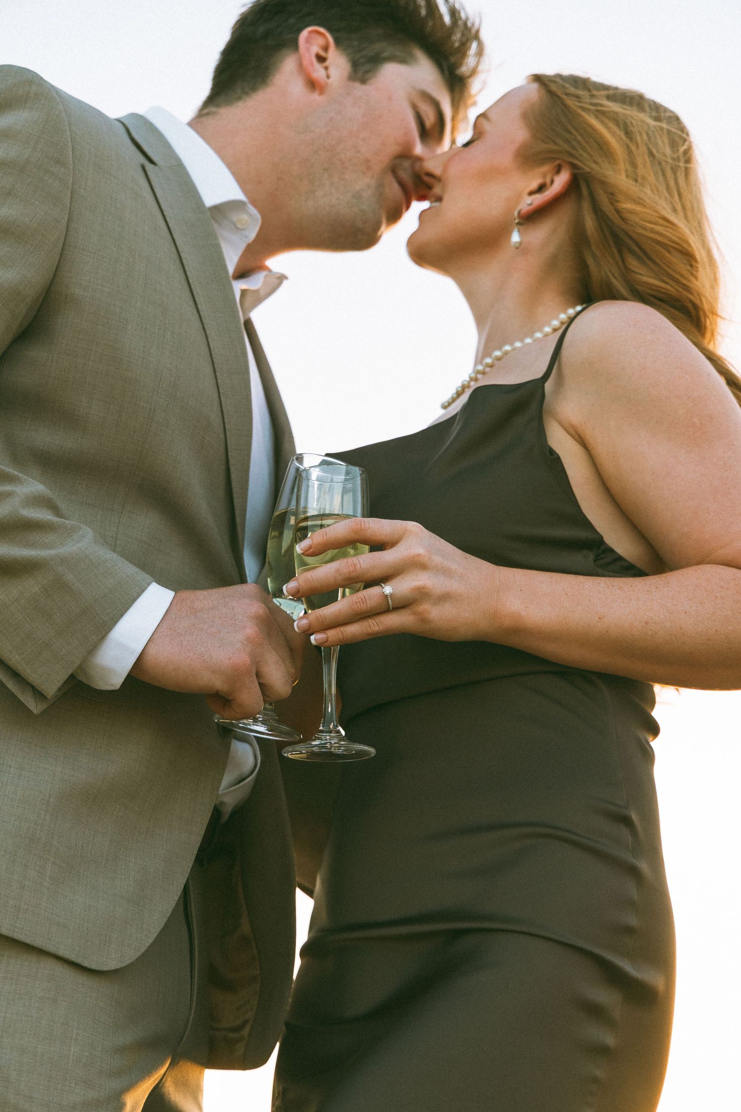 couple kissing while holding champagne flutes