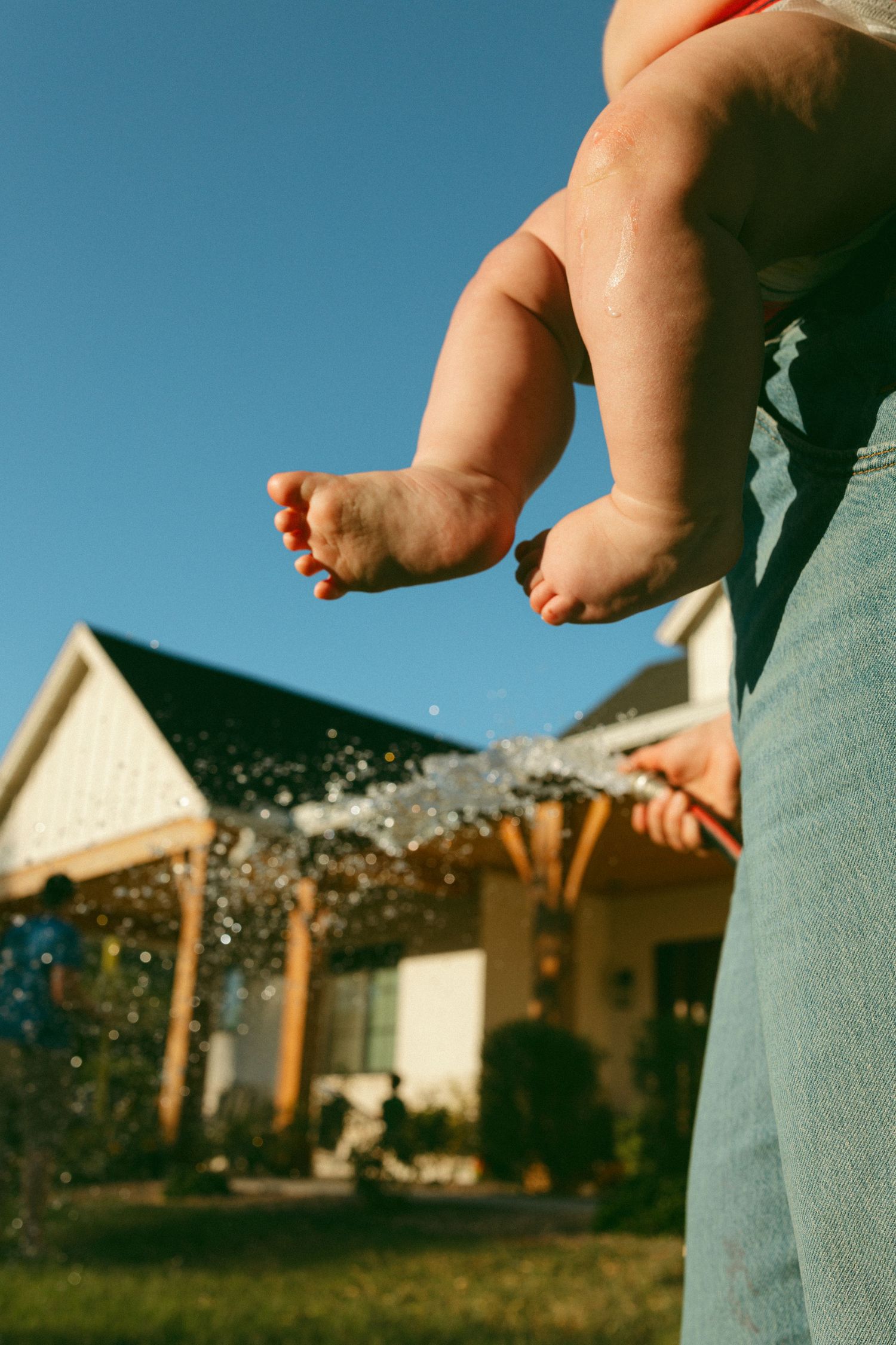 baby feet in the setting sun with water hose