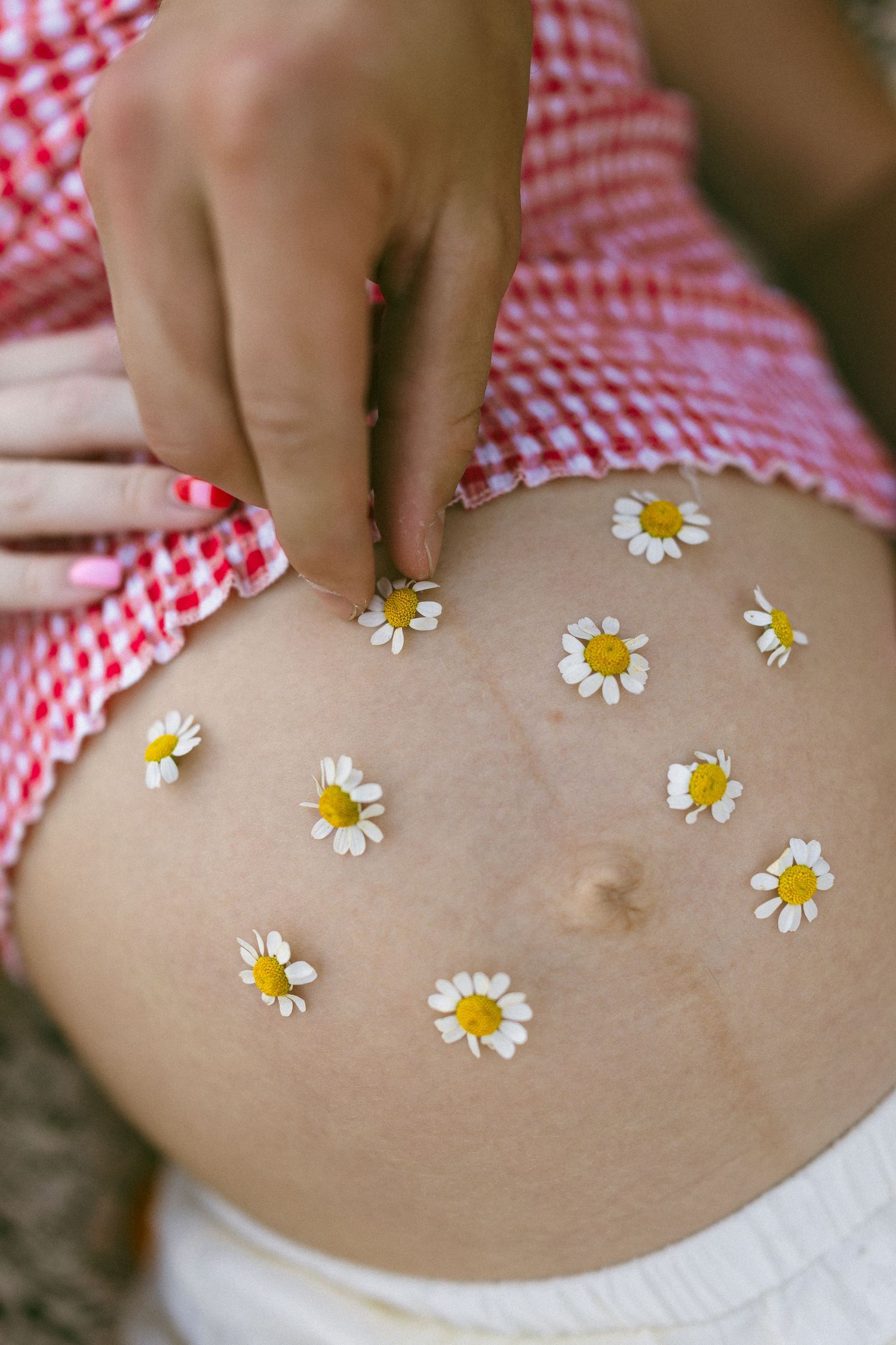 little white flowers on a pregnant belly