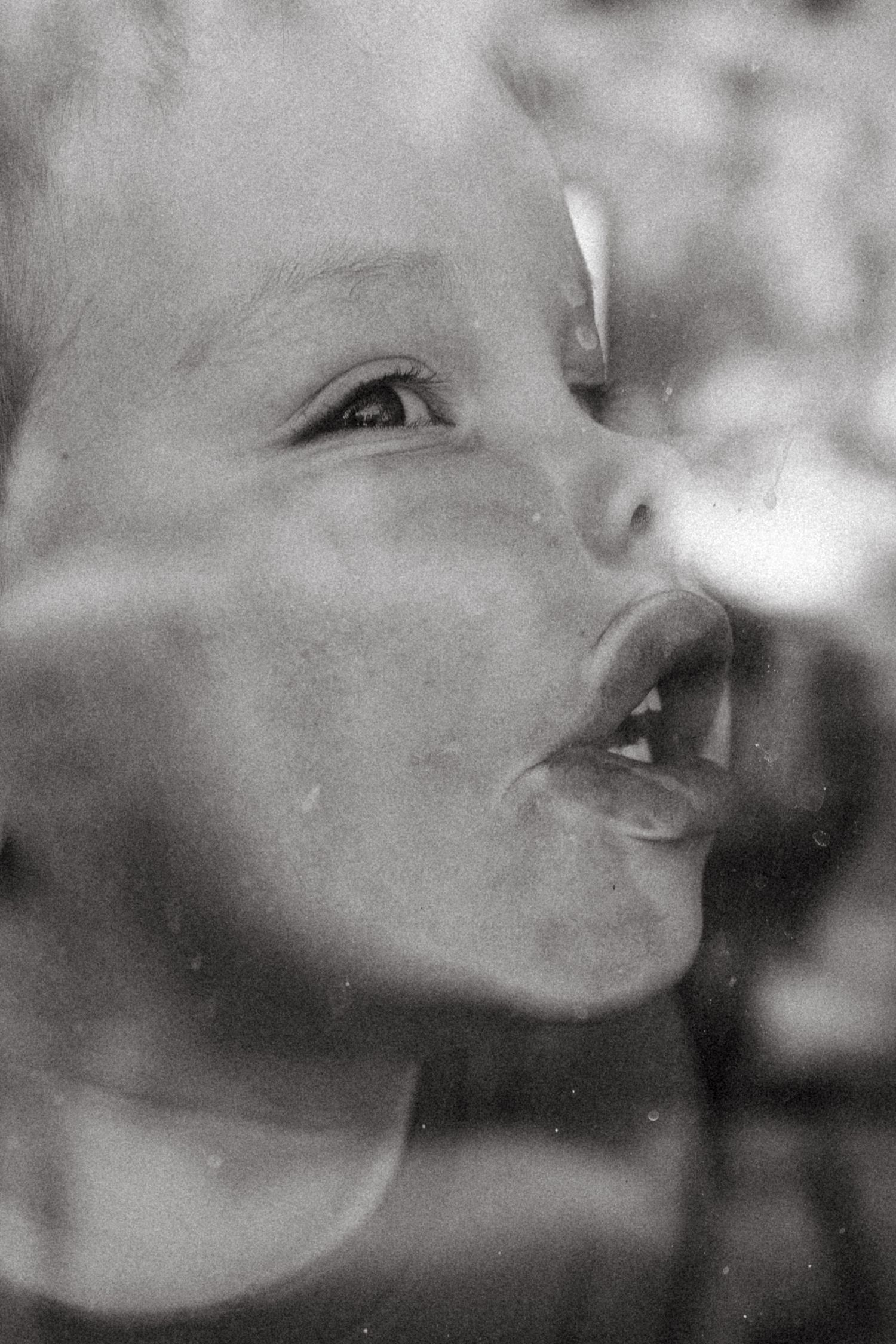 child making faces through the window