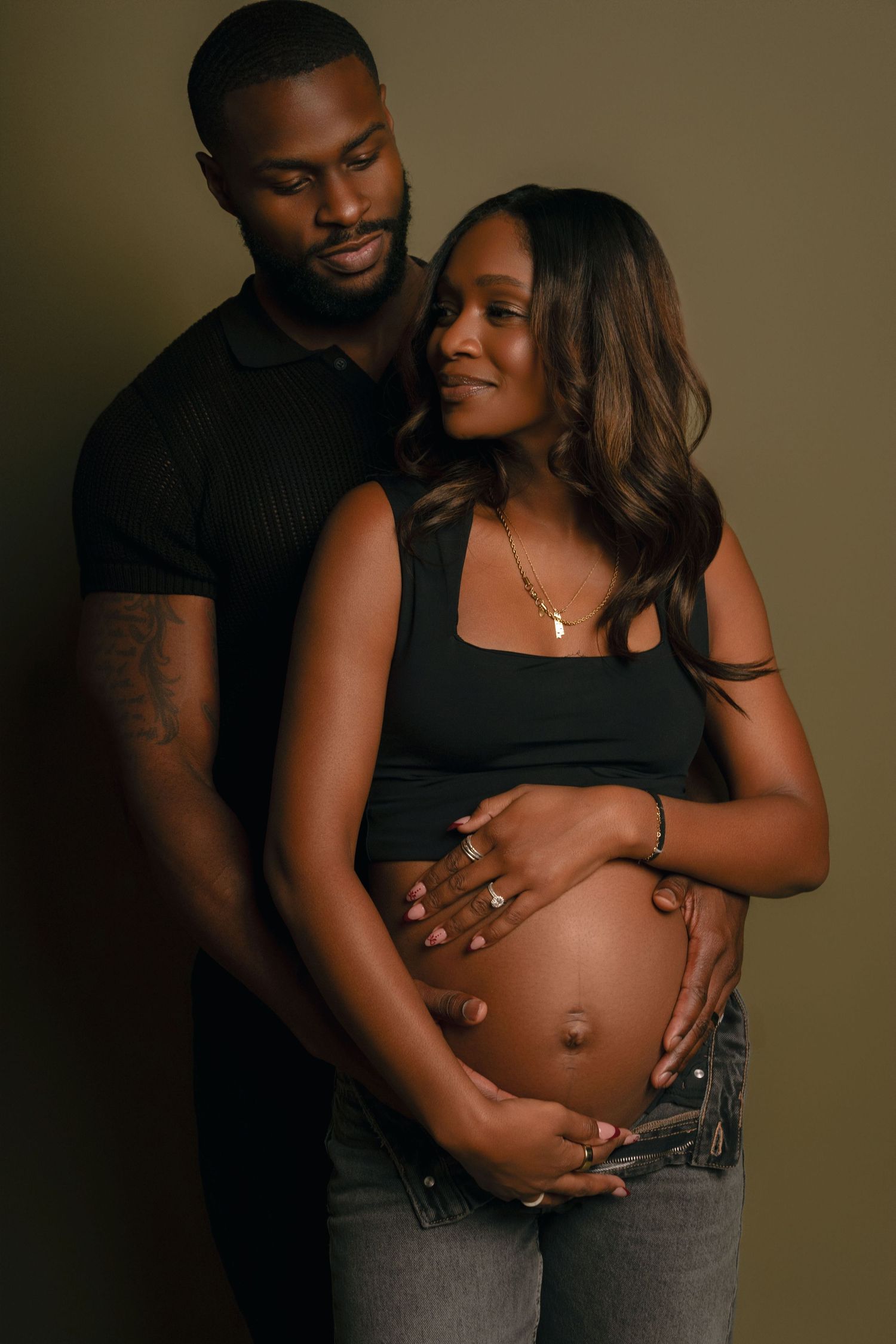 Atlanta maternity photography of an expecting couple embracing during an intimate studio portrait session.