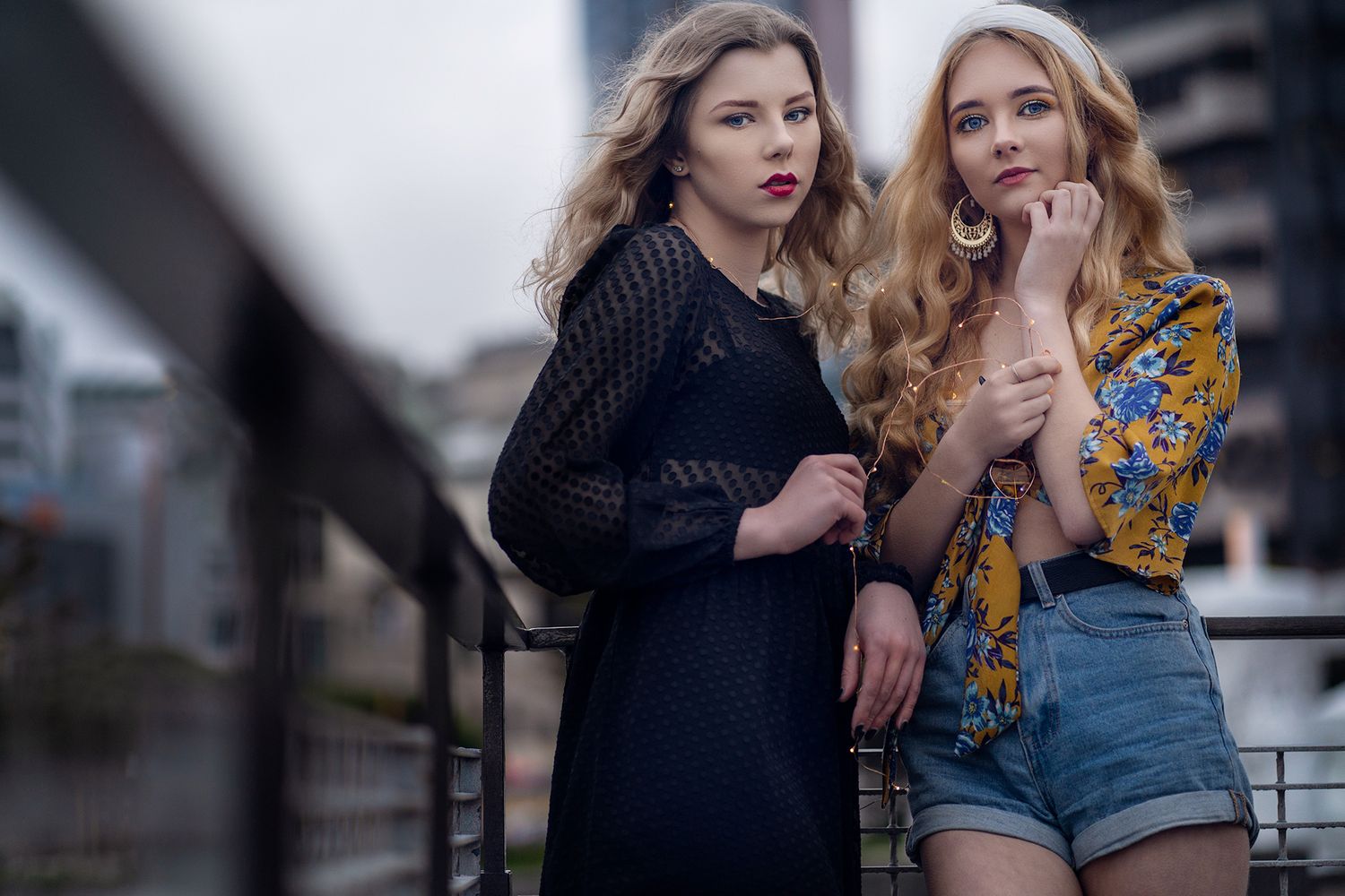 Fashion editorial featuring contrasting styles and urban backdrop.
