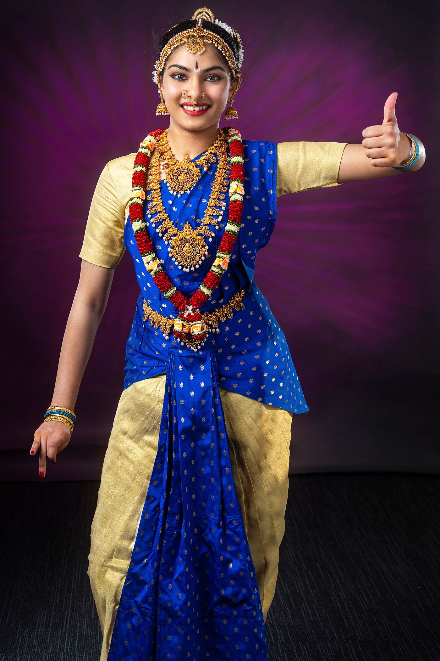 Performer in blue and gold traditional Indian dance costume striking dynamic poses.