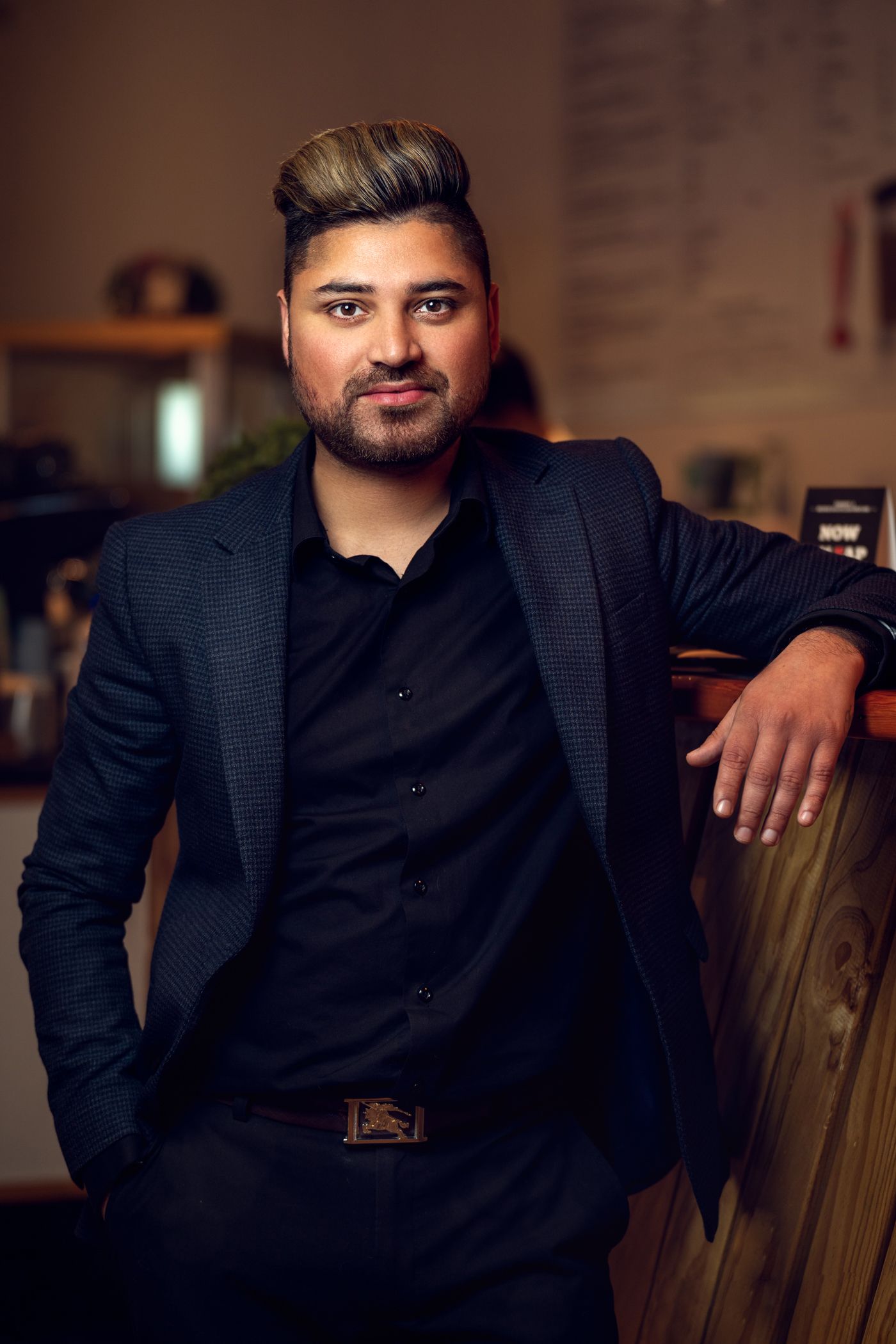 Professional portrait series in dark formal attire against moody lighting.