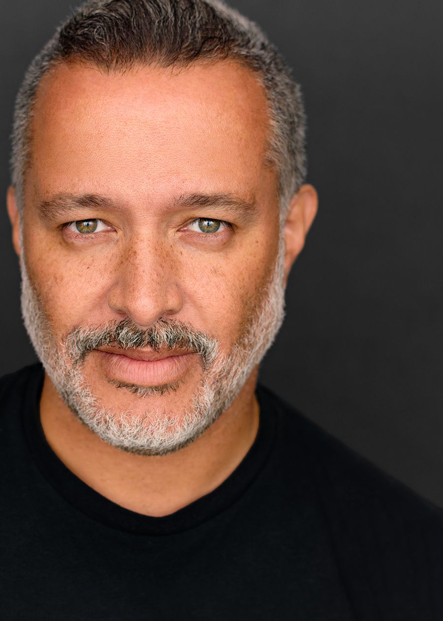 Professional headshot portrait on dark background.