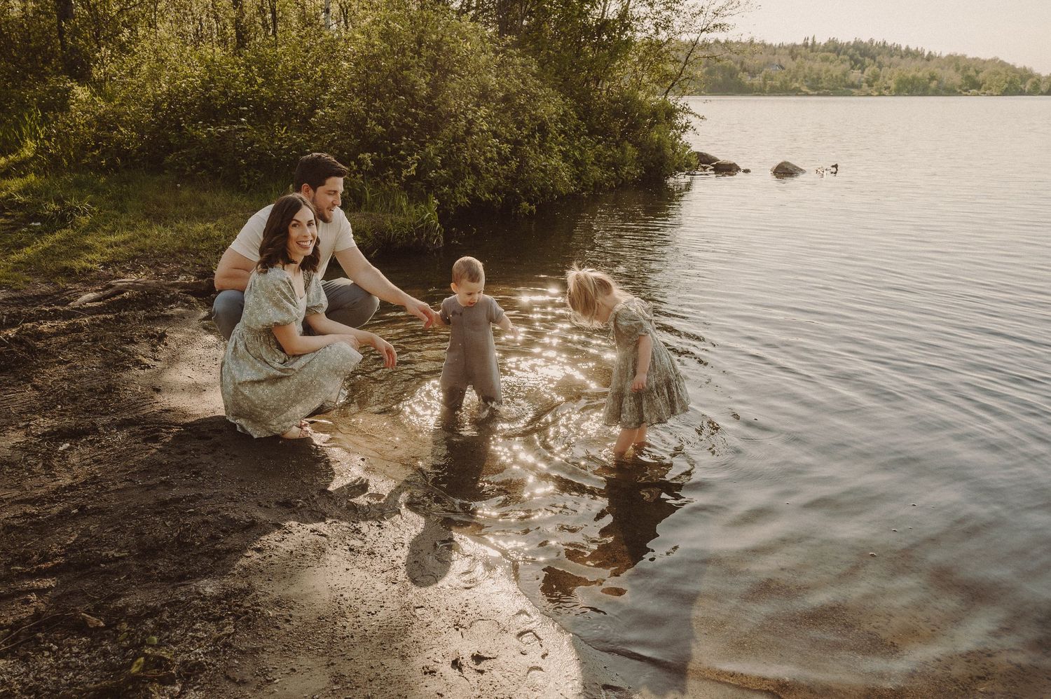 Famille jouant ensemble au bord d’un lac pendant l’heure dorée.