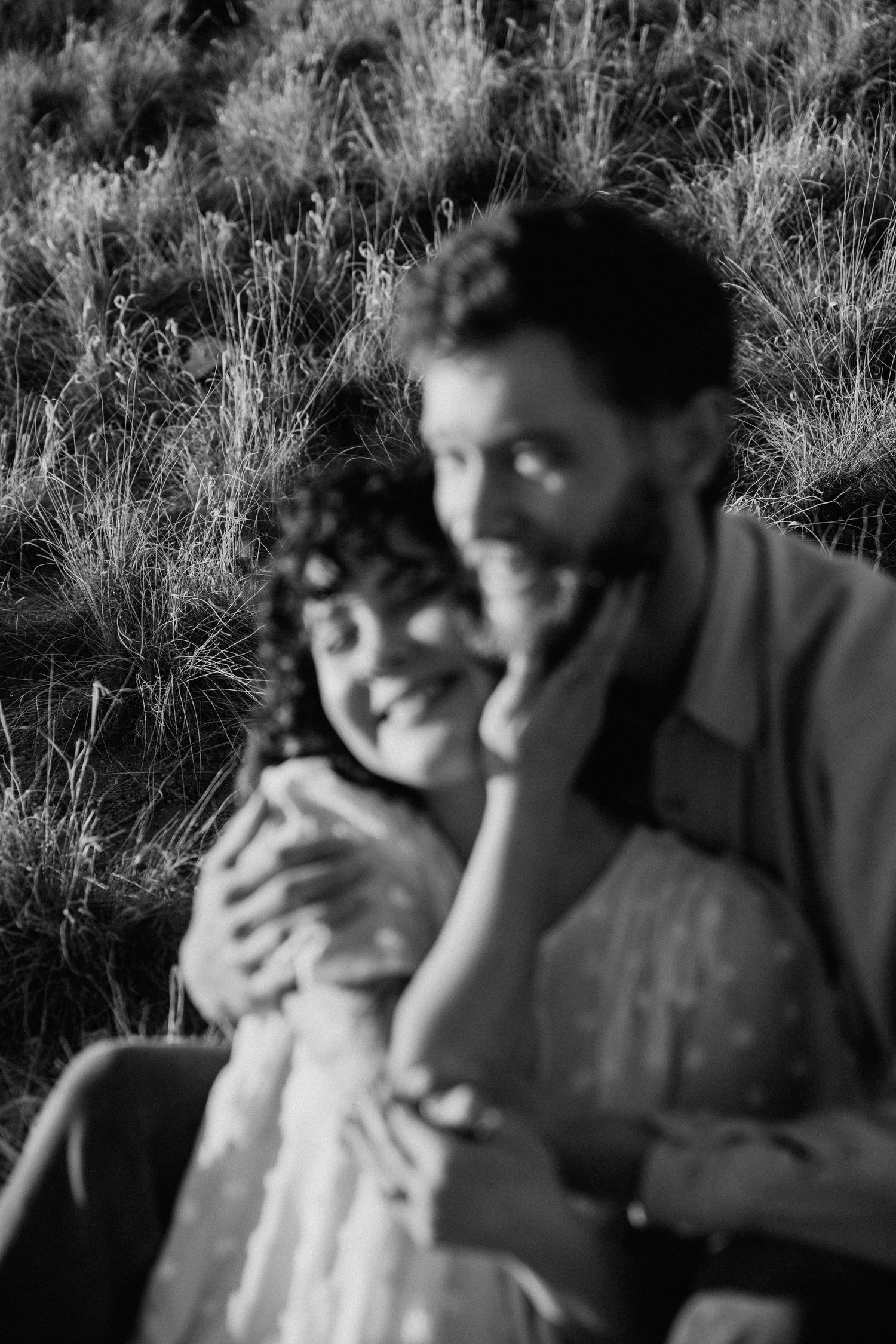 Intimate black and white engagement session in Taos NM with couple embracing in tall desert grass