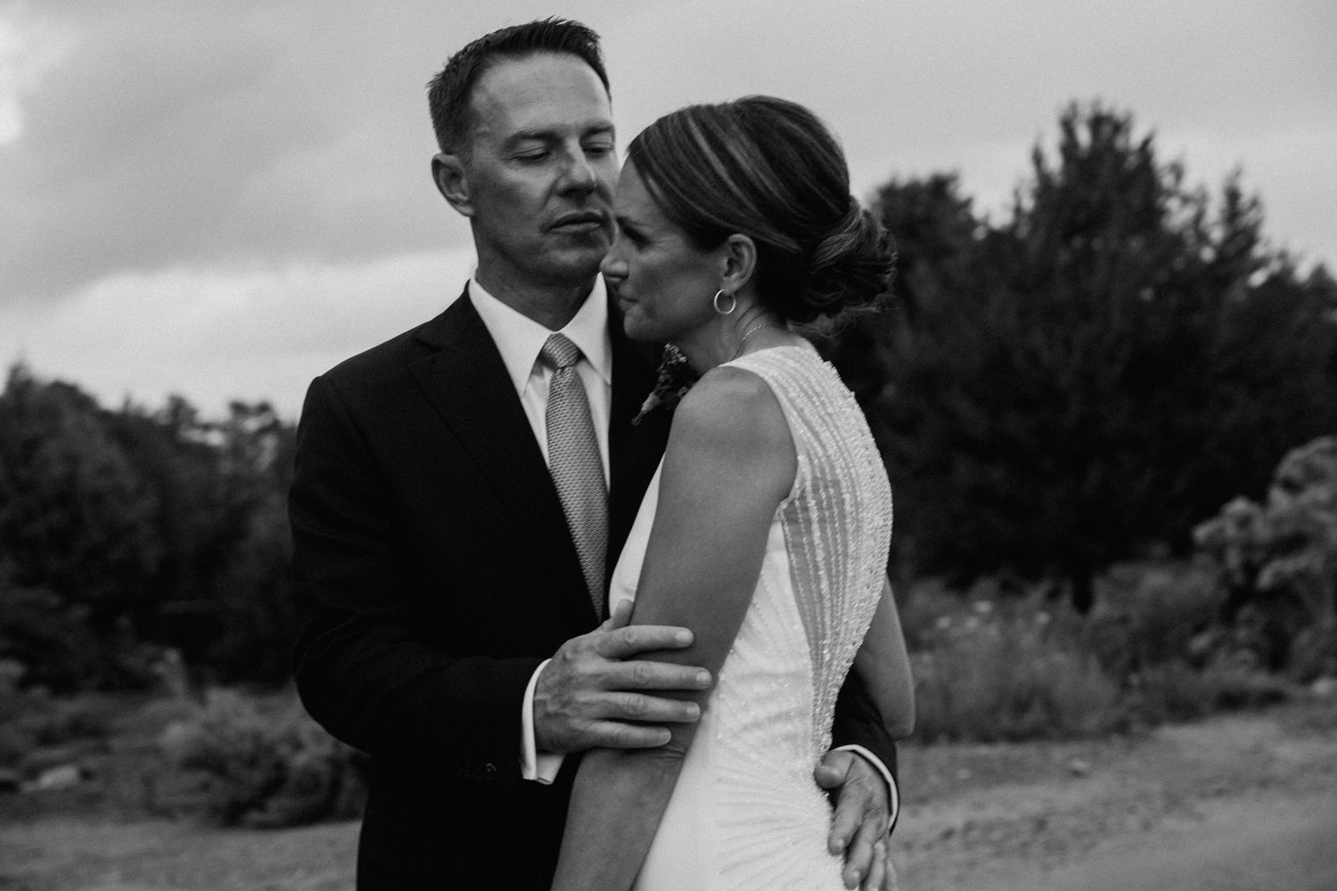 Black and white wedding photo collage showing intimate moments between newlyweds in outdoor settings.