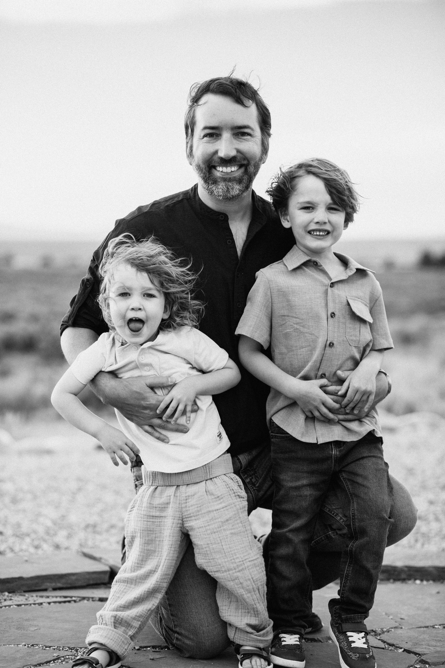Black and white portrait of joyful moments shared between family members outdoors.