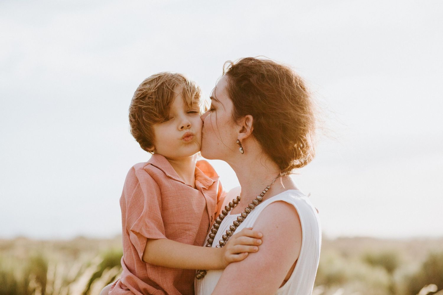 Tender family moment captured during golden hour outdoors.