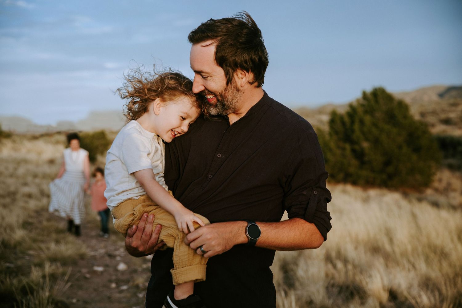 Candid family moments captured during golden hour in a desert landscape.