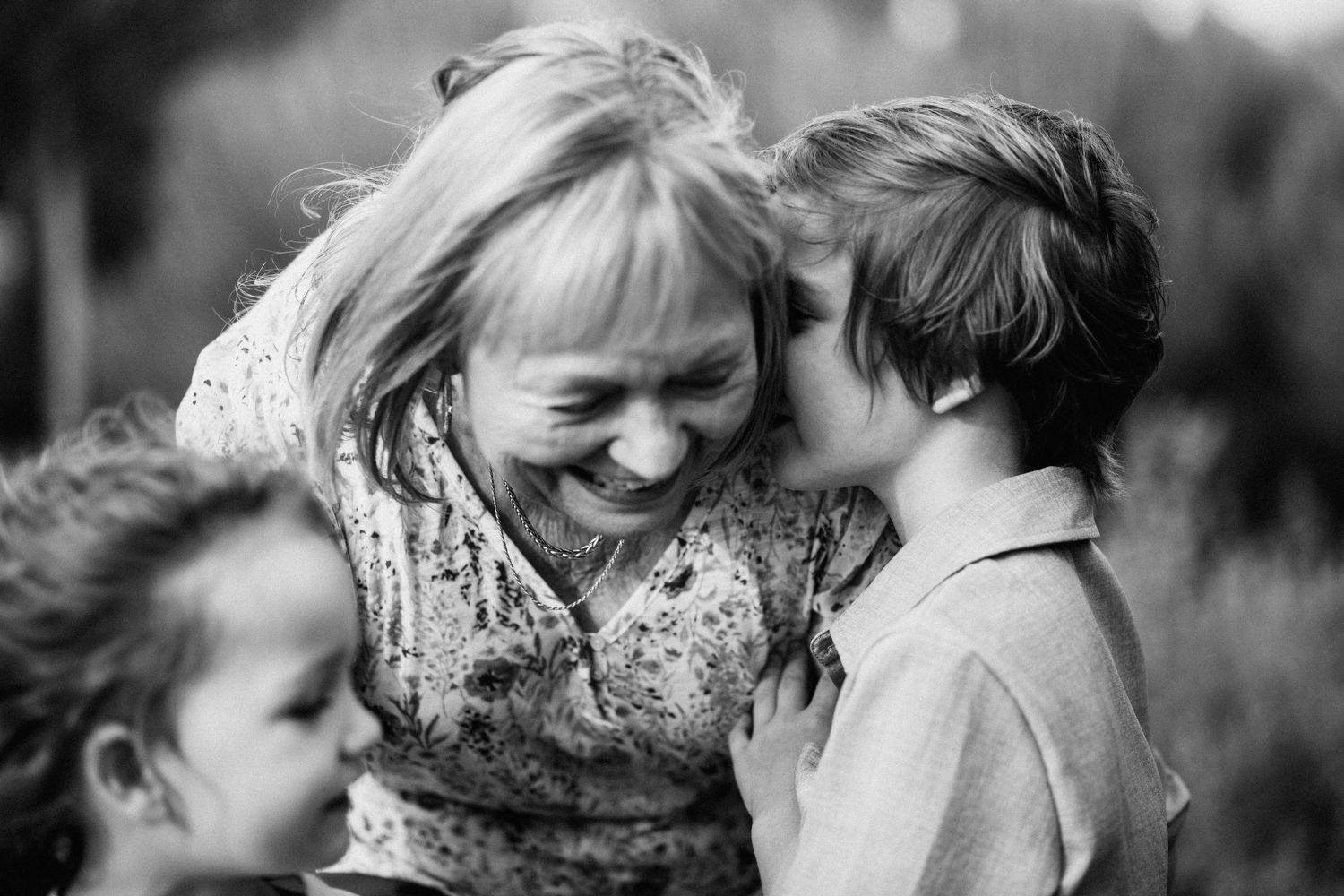 Black and white candid moment of shared joy and laughter between family members.