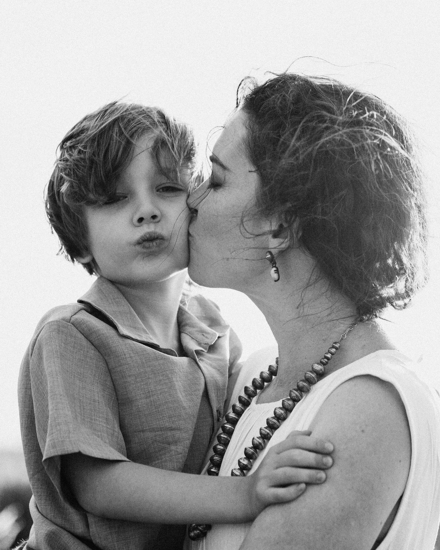 Black and white photo series showing tender moments of affection and embraces in natural light.