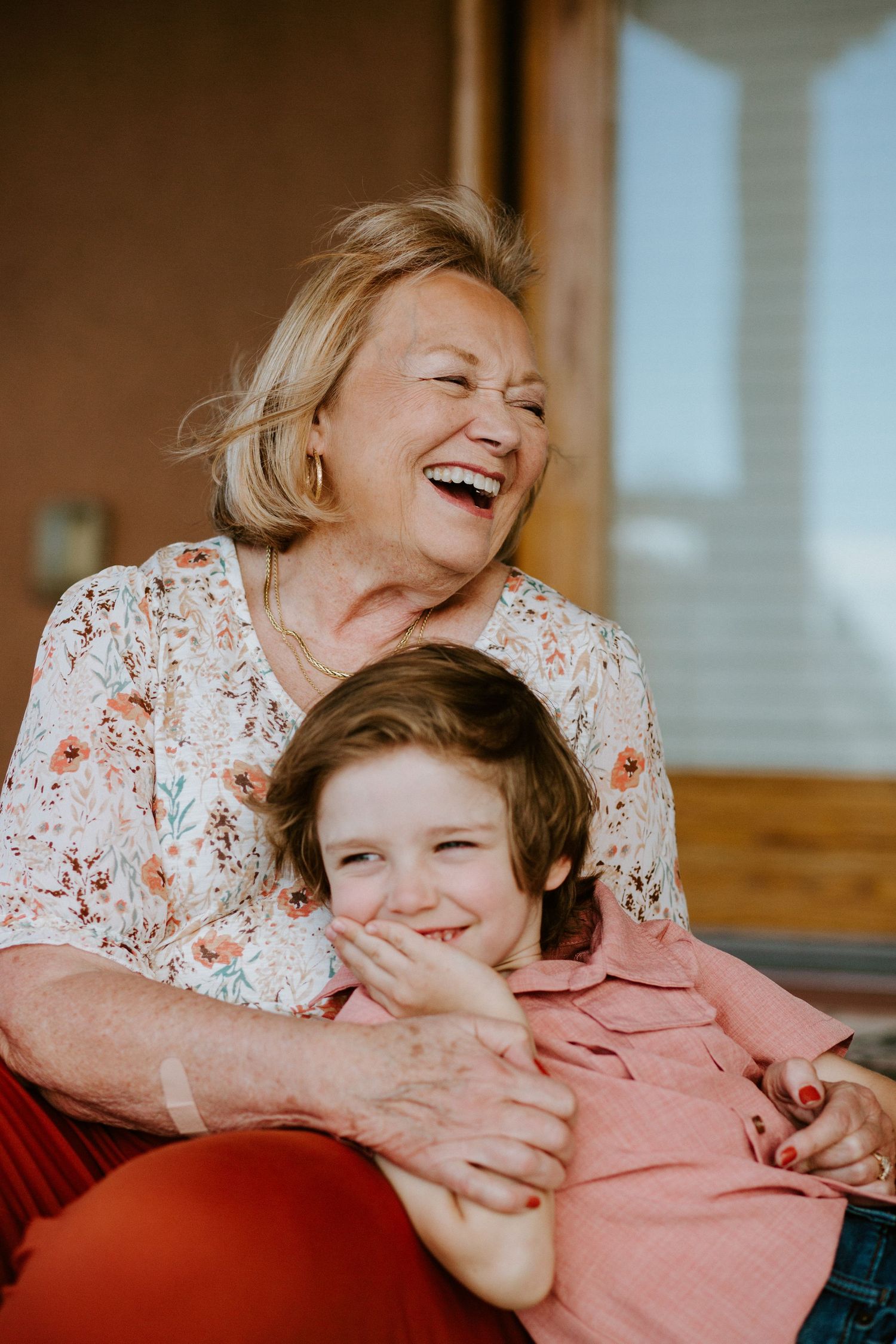 Warm-toned sequence of joyful embraces and laughter between two people on a couch.