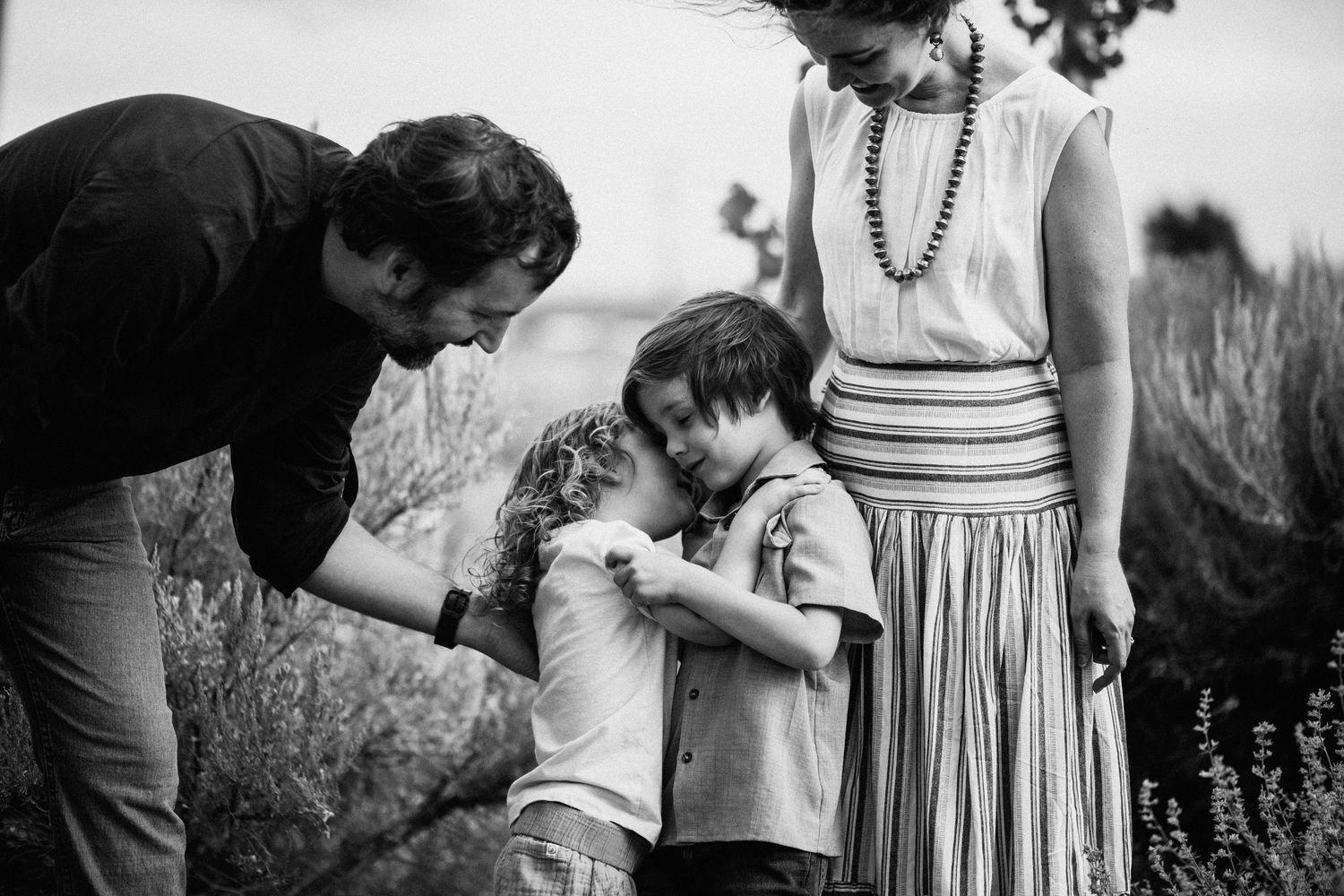 Black and white candid shots capture intimate family moments in outdoor setting.