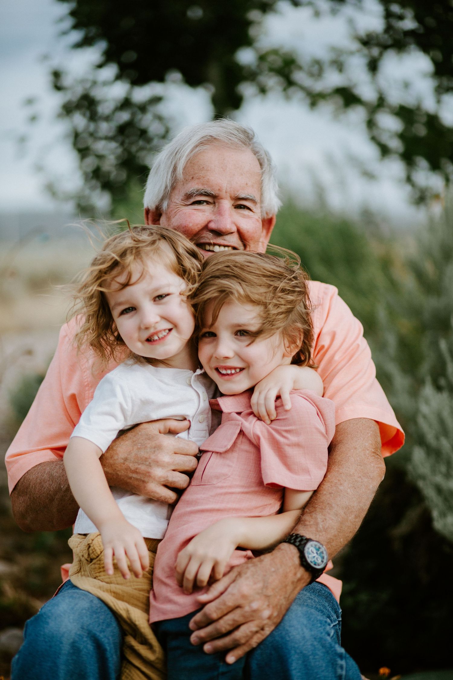 Heartwarming family embrace captured in outdoor setting with natural lighting.