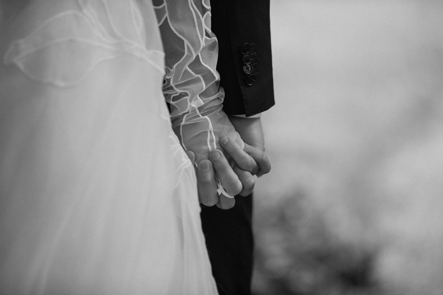 Black and white close-up detail of formal wedding attire.