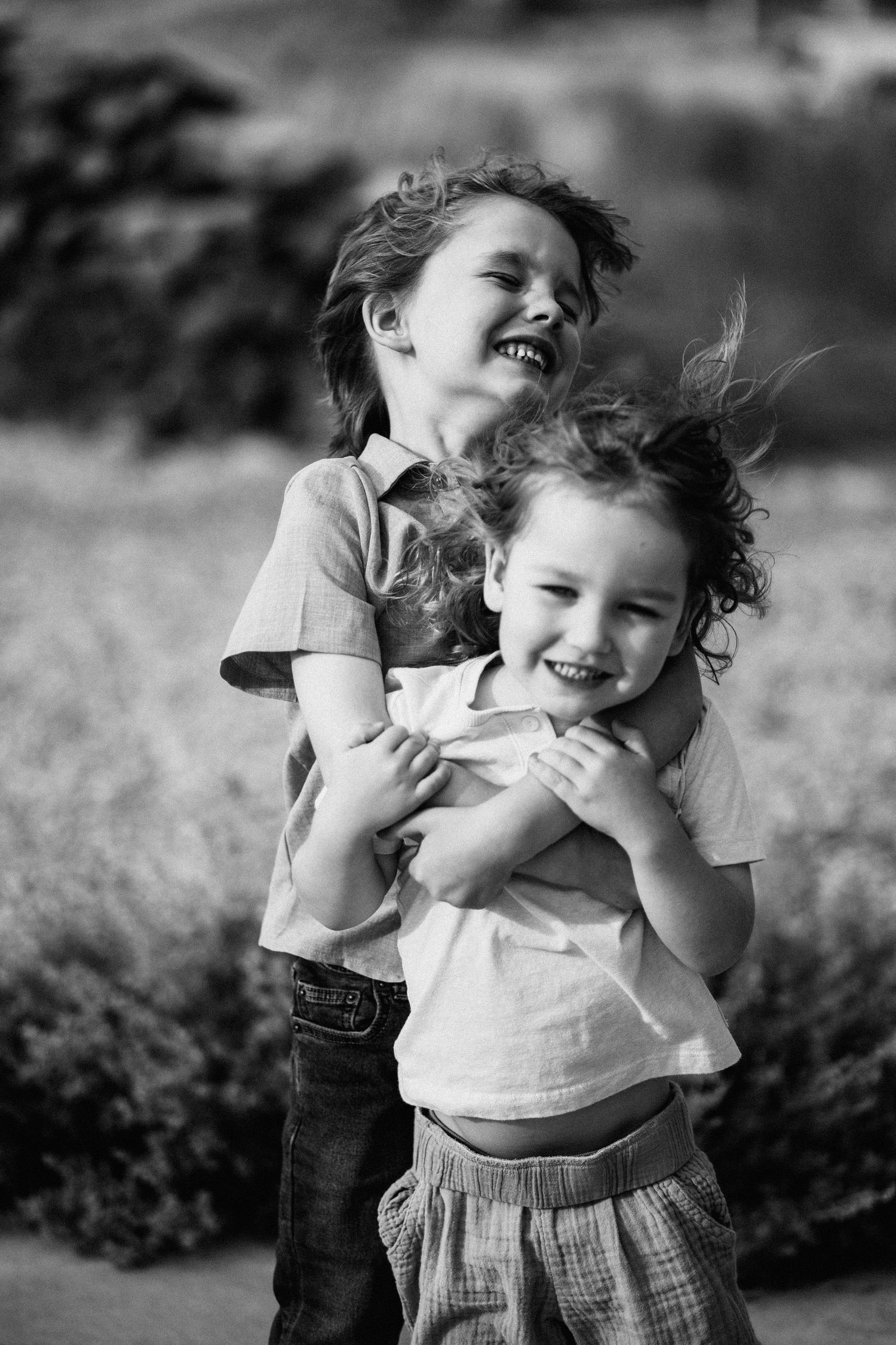 Black and white series showing playful interactions between two people outdoors.
