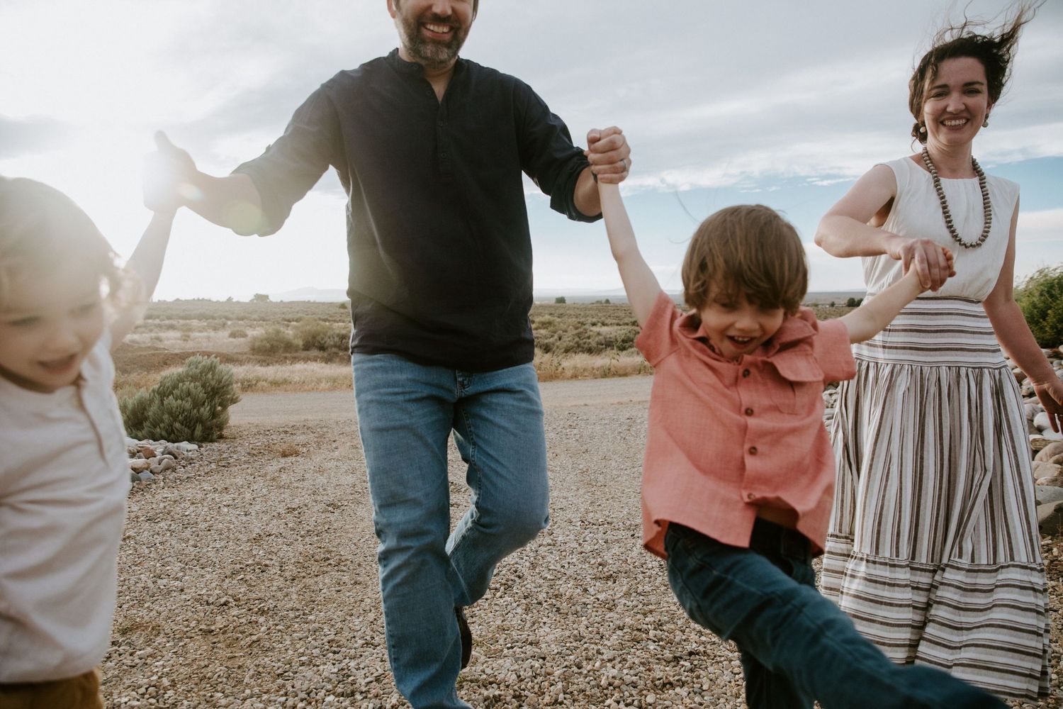 Family members playing and jumping together on outdoor patio.  Shot in Taos, NM by Siouxzen Kang
