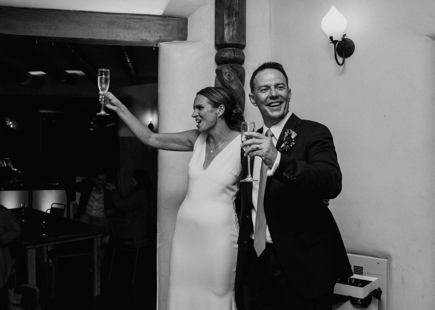 A wedding couple shares joyful moments in a series of black and white candid photographs during their celebration.