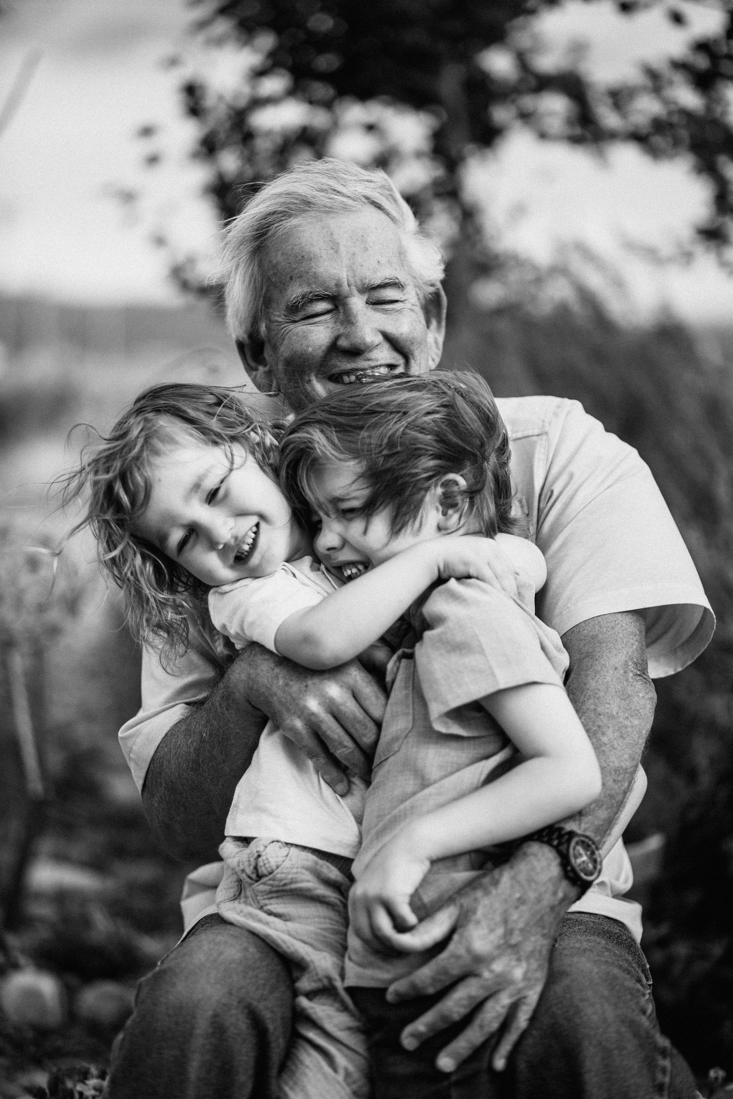 A black and white photo series showing a tender moment between a child and adult embracing outdoors.