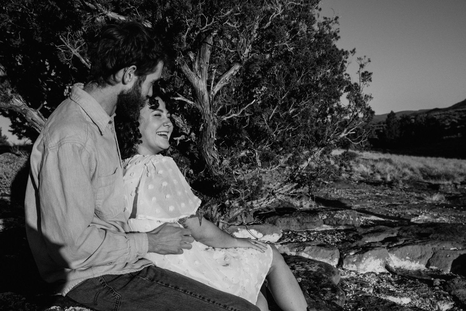 A black and white photo series showing people sitting outdoors on rocks and enjoying nature together.