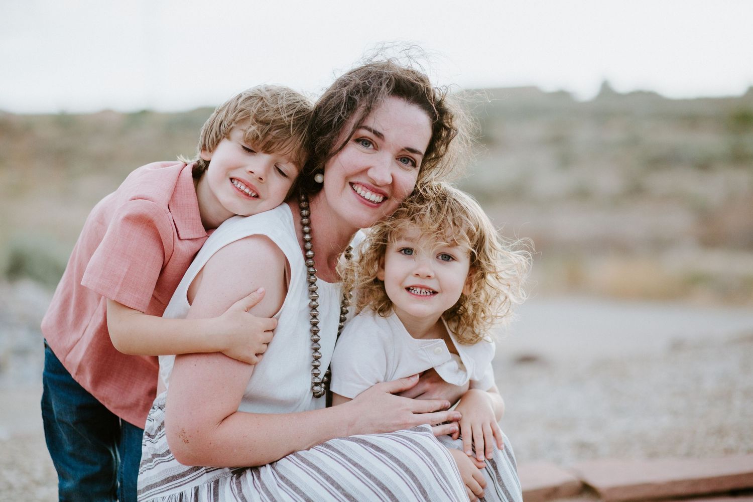 Candid photos capturing warm embraces and laughter in an outdoor desert setting.
