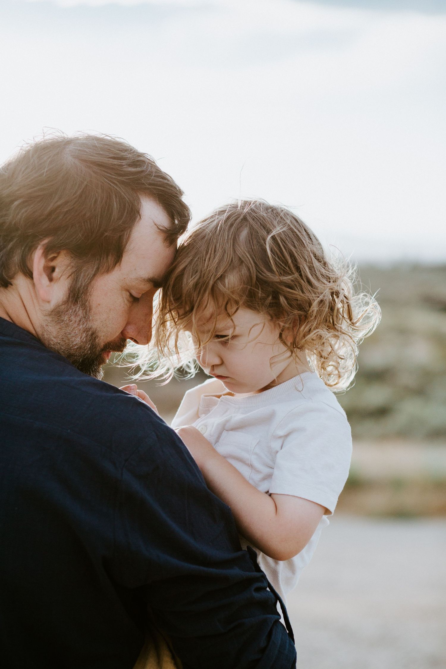 Series of intimate close-up shots showing parent and child sharing affectionate moments against a bright background.