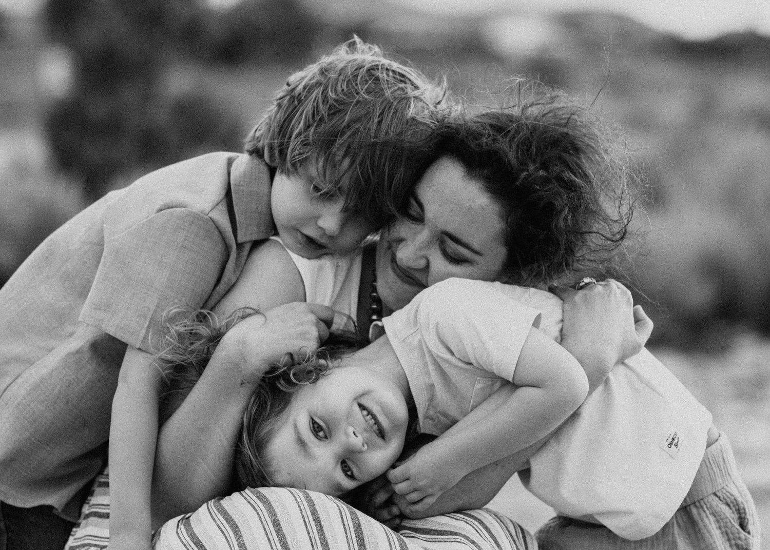 Intimate black and white photographs capture loving embraces between family members.