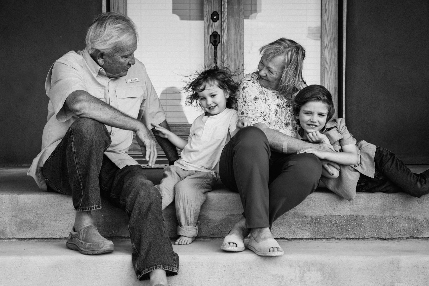 Black and white series showing intimate family interactions on a porch setting.