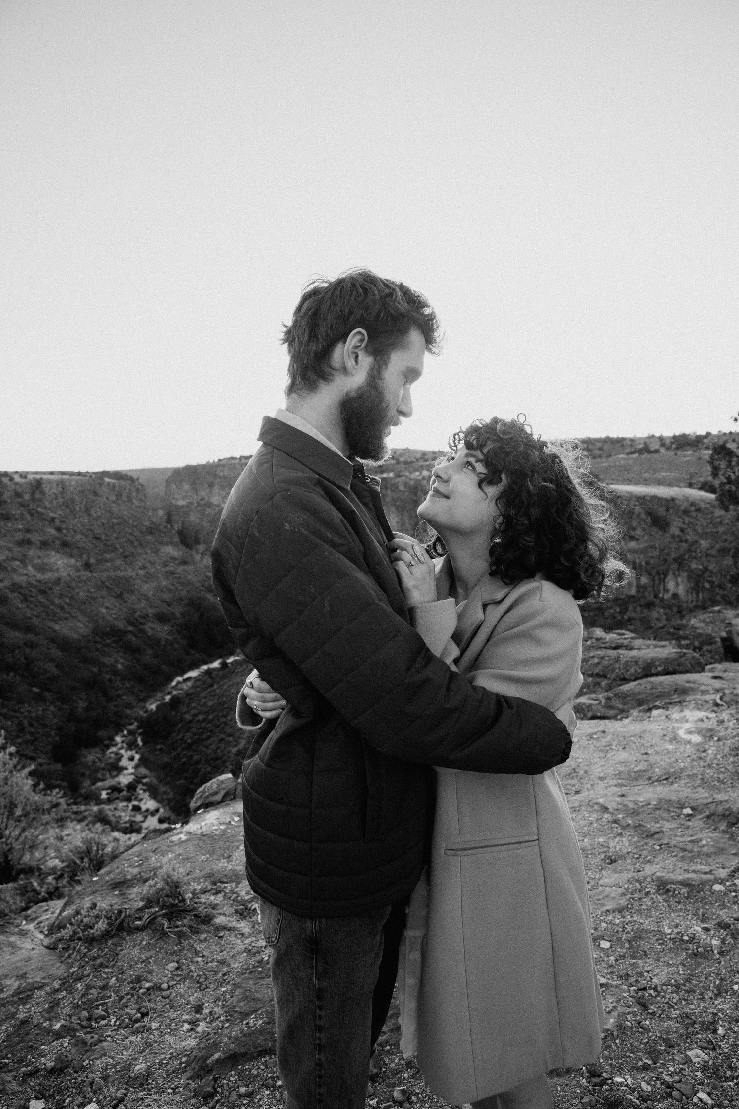 Black and white engagement session in Taos, New Mexico capturing intimate moments between a couple on a rocky hillside