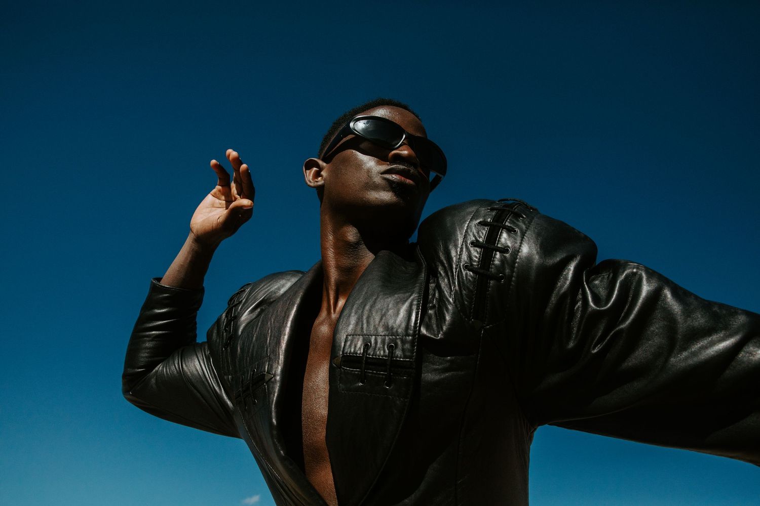 Silhouette of person in leather jacket against dramatic blue sky.  Shot in Taos, NM by Siouxzen Kang