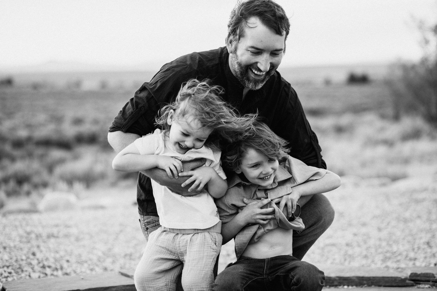 Black and white sequence showing tender moments of play and laughter outdoors.