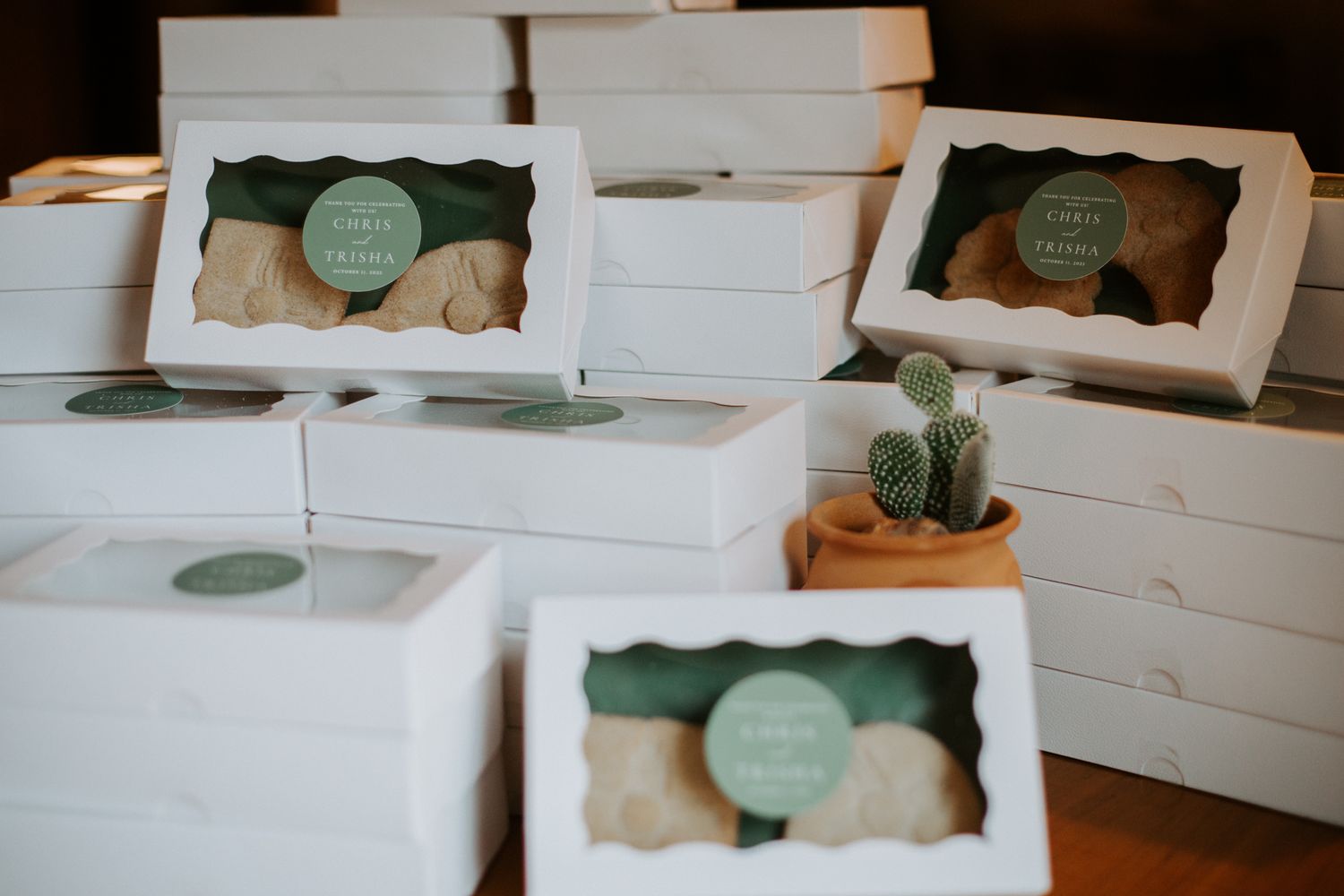 White gift boxes with mint green decorative labels arranged in neat rows.