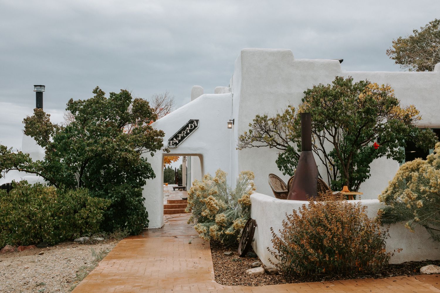 White stucco buildings and pathways along a Mediterranean coastal landscape with blue skies.