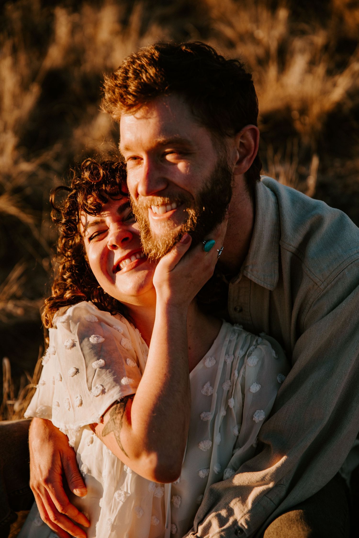 Couple sharing a tender moment during golden hour engagement session in Taos New Mexico desert landscape