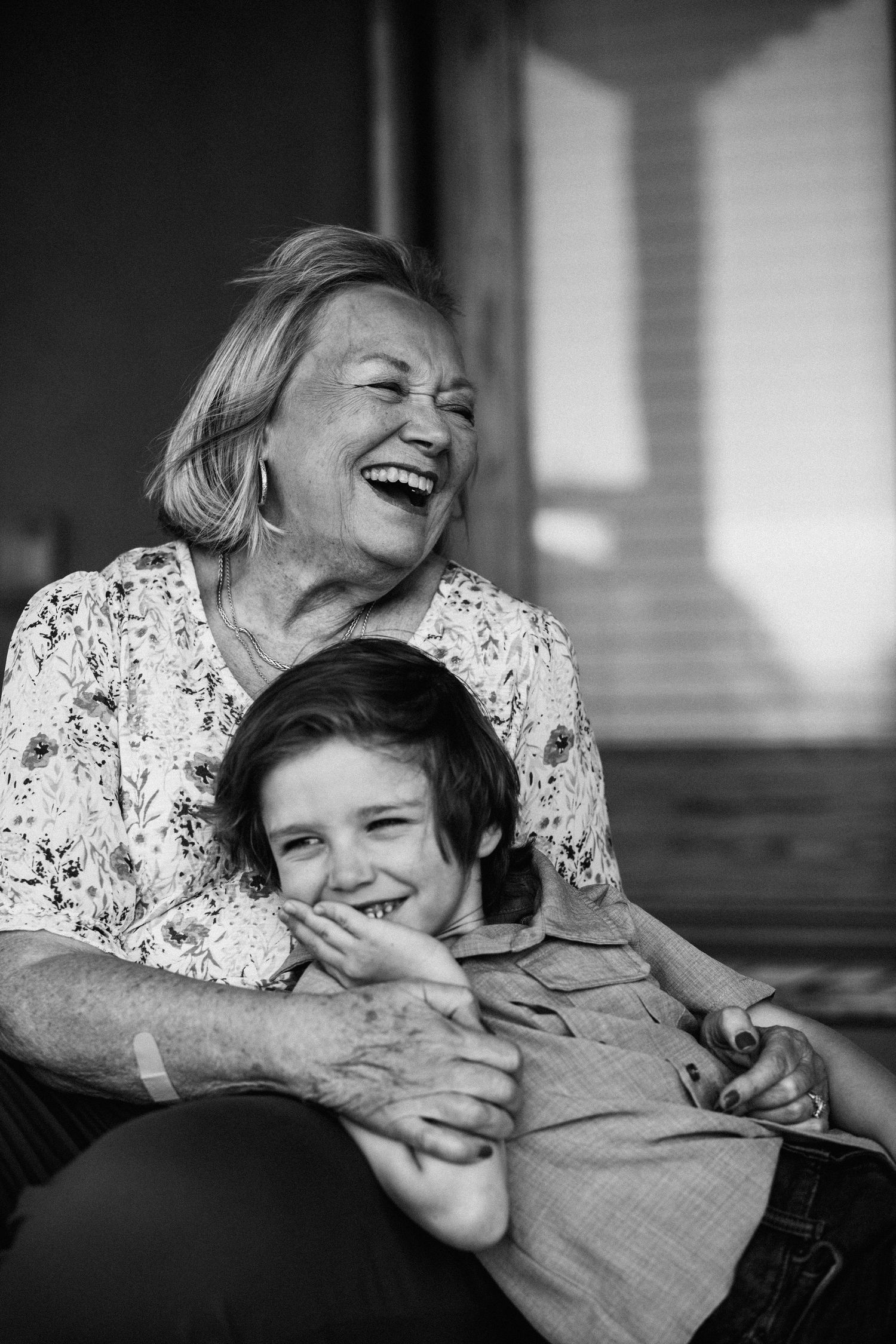 Black and white photos showing joyful laughter and embraces between generations.