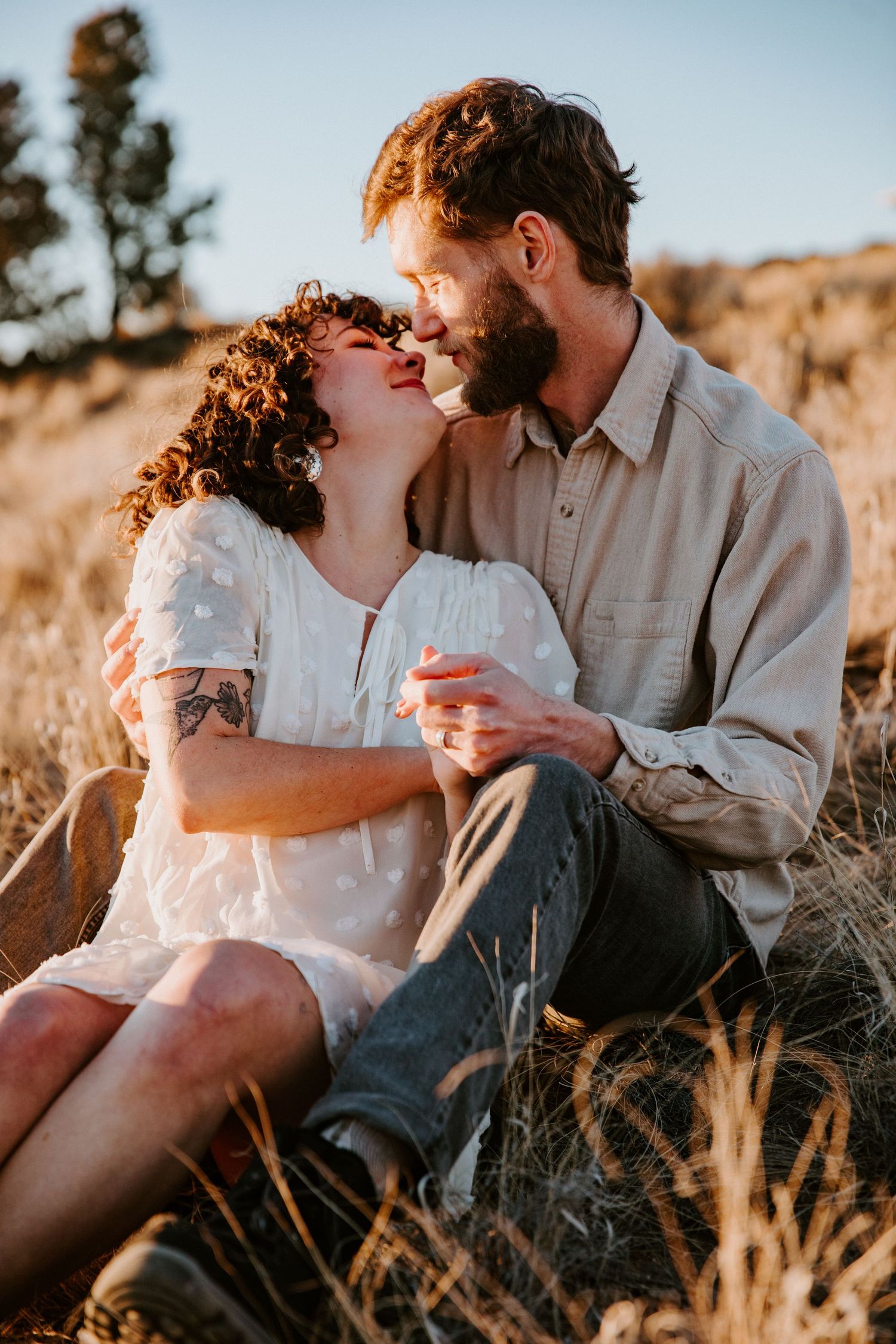 Couple sharing an intimate moment during golden hour engagement session in Taos, New Mexico desert landscape