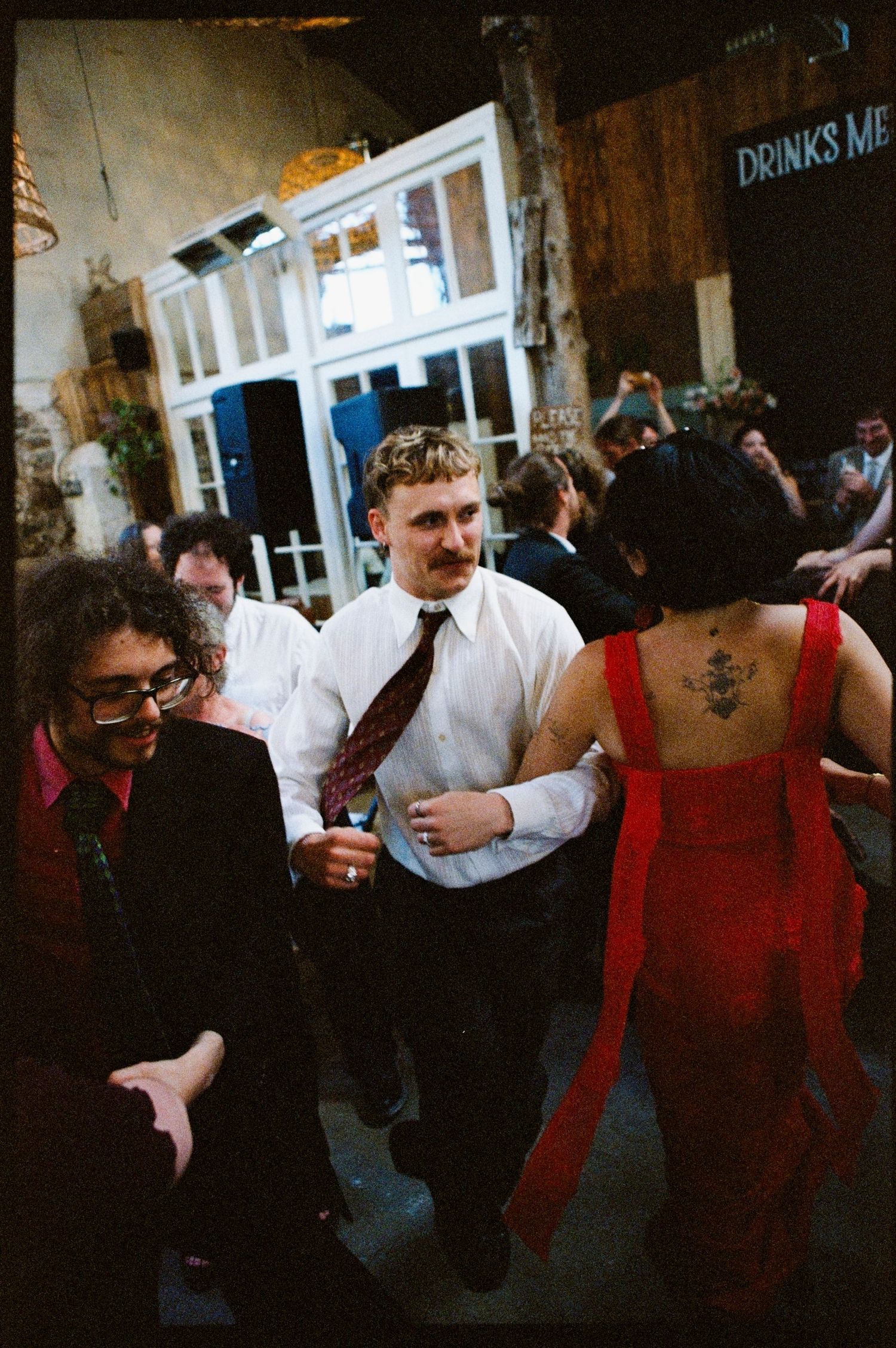 People dancing at a lively indoor wedding reception party venue.