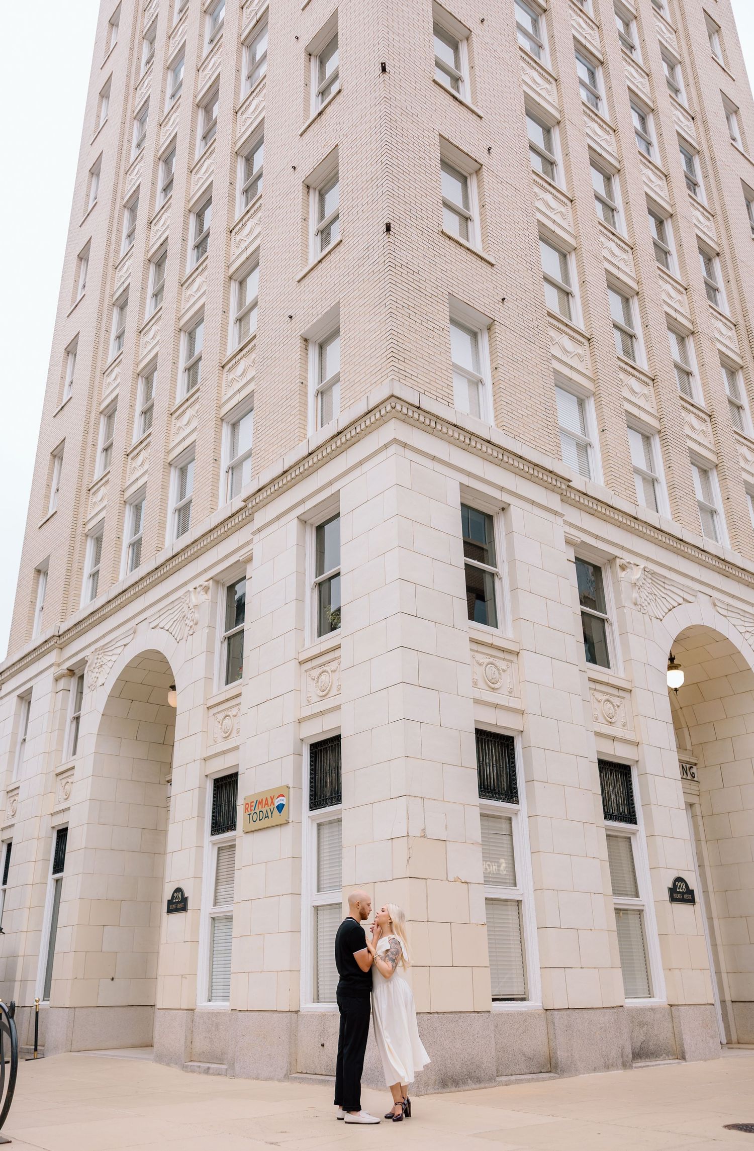 A tall beige stone building with arched windows and architectural details.