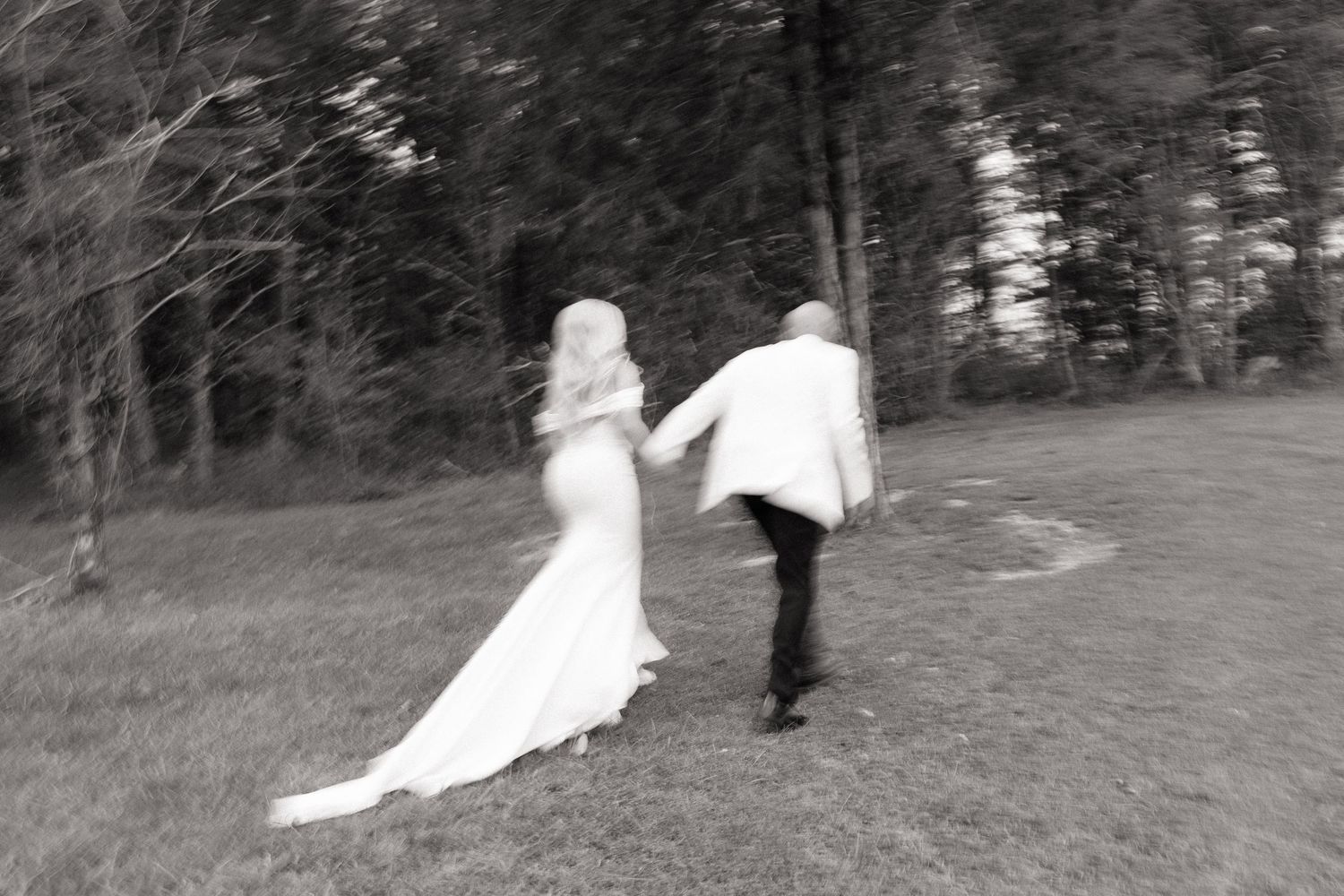 Black and white photo series showing a flowing wedding dress train on grassy ground.
