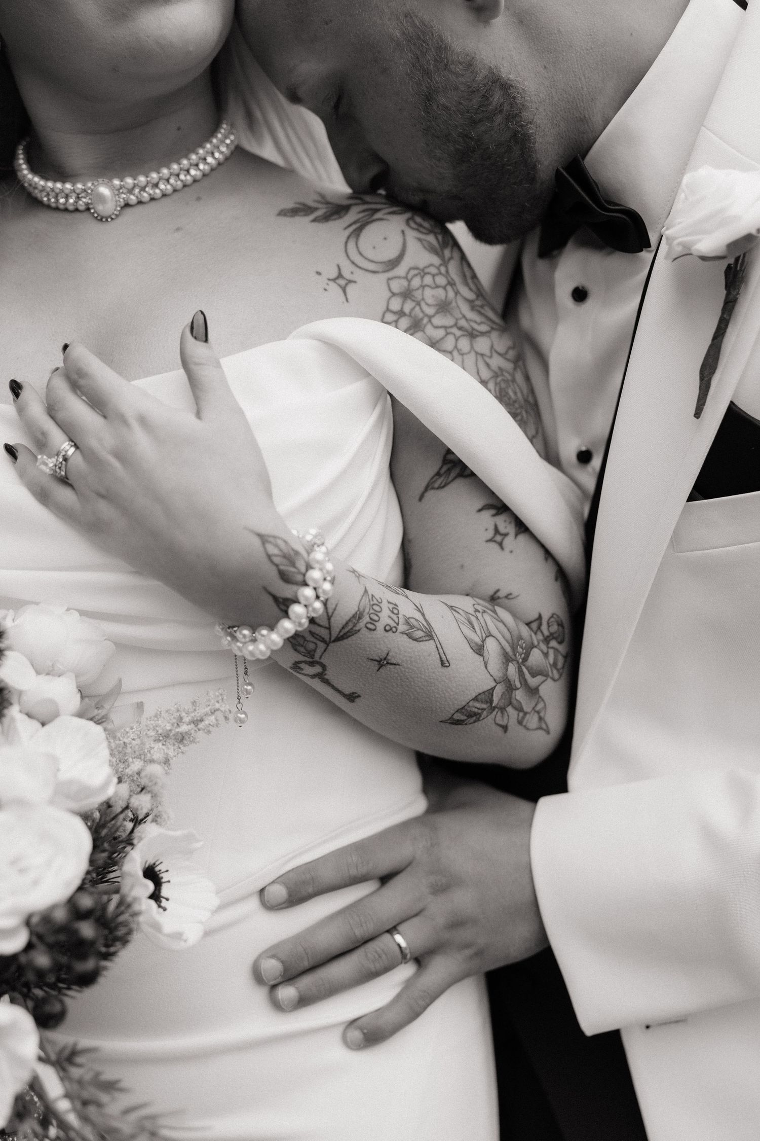 A black and white photo montage shows multiple close-up shots of hands touching formal wedding attire.