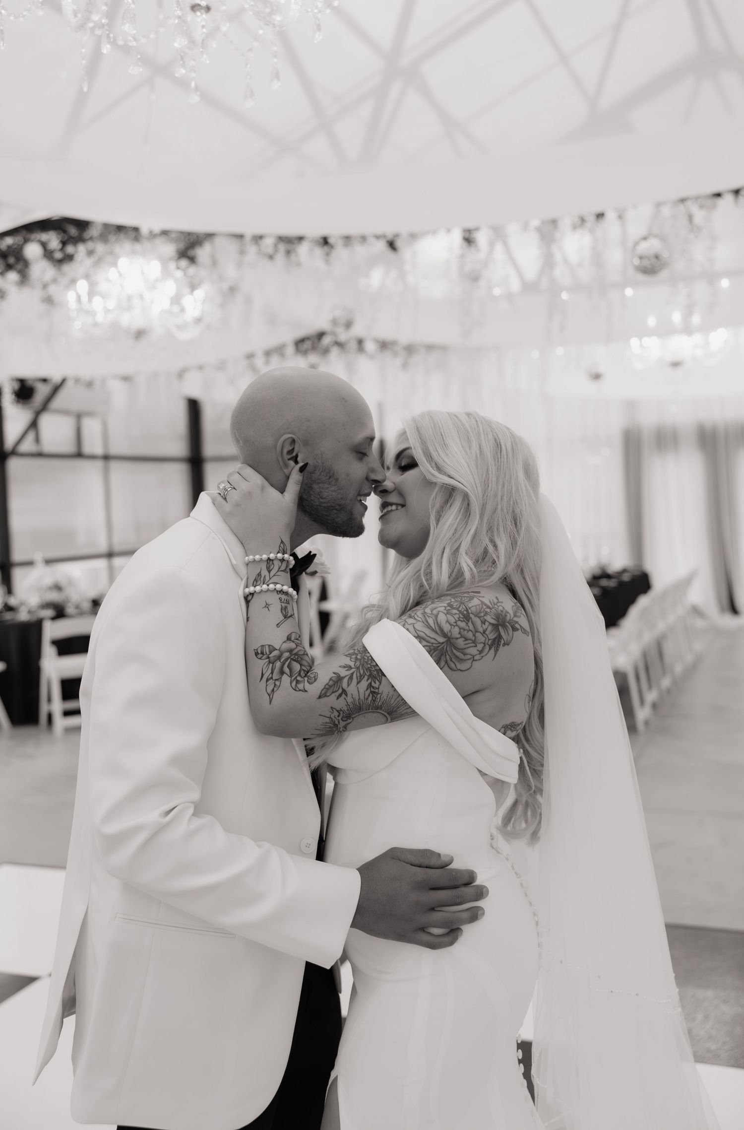 Wedding celebration under a white tent with string lights creating a romantic atmosphere.