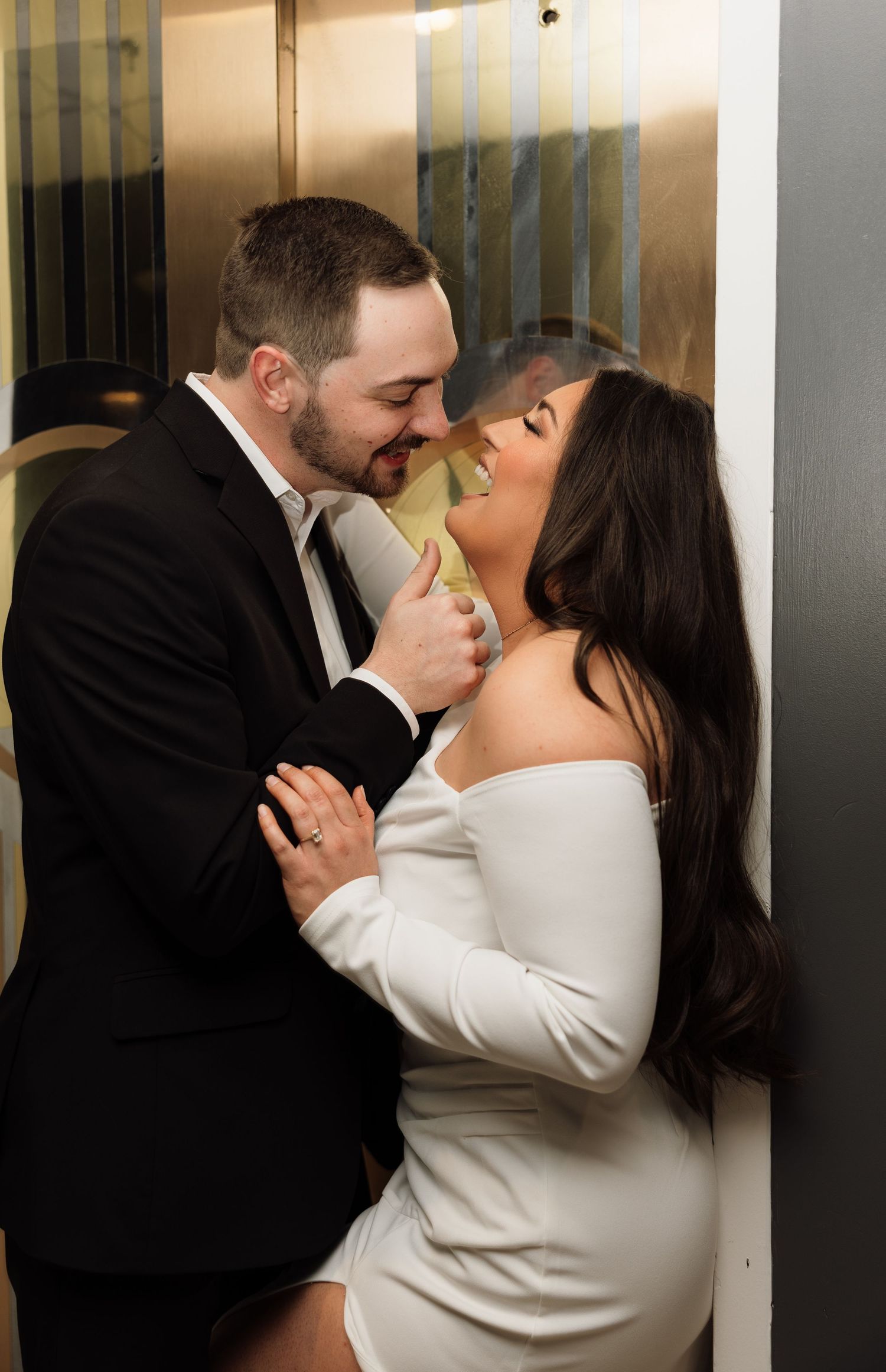 Intimate moment between newlyweds in a warmly lit indoor setting.