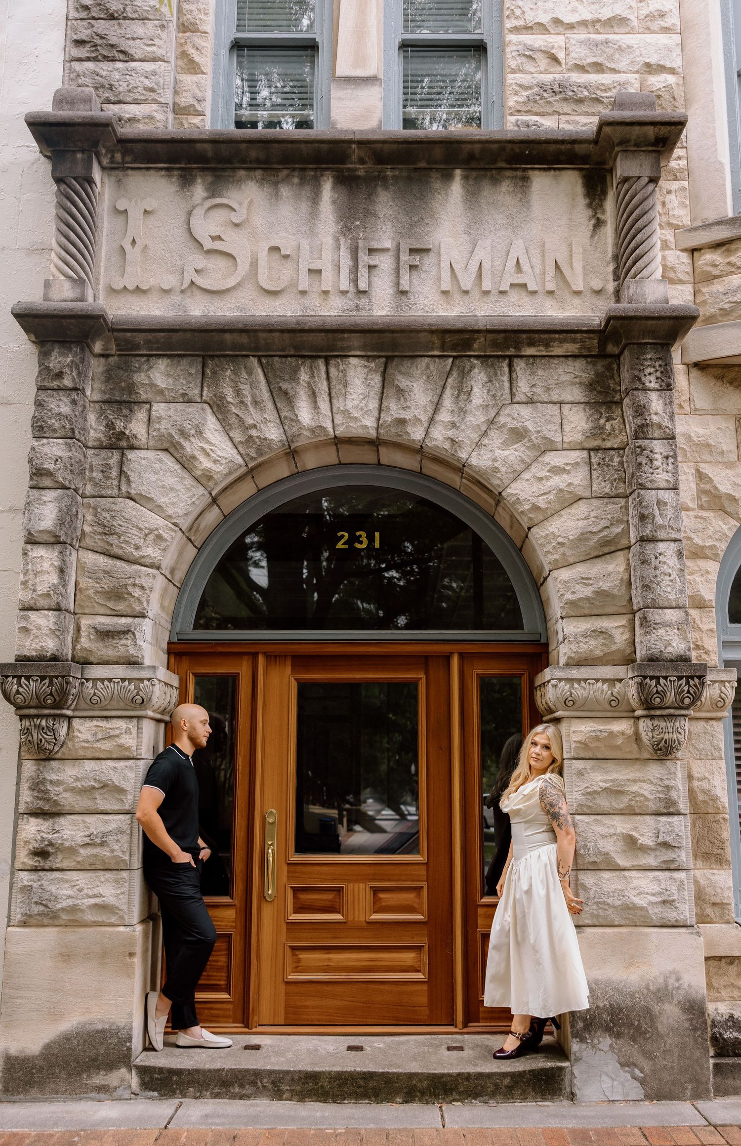 Historic stone building entrance with 'Schiffman' engraved above wooden doors.