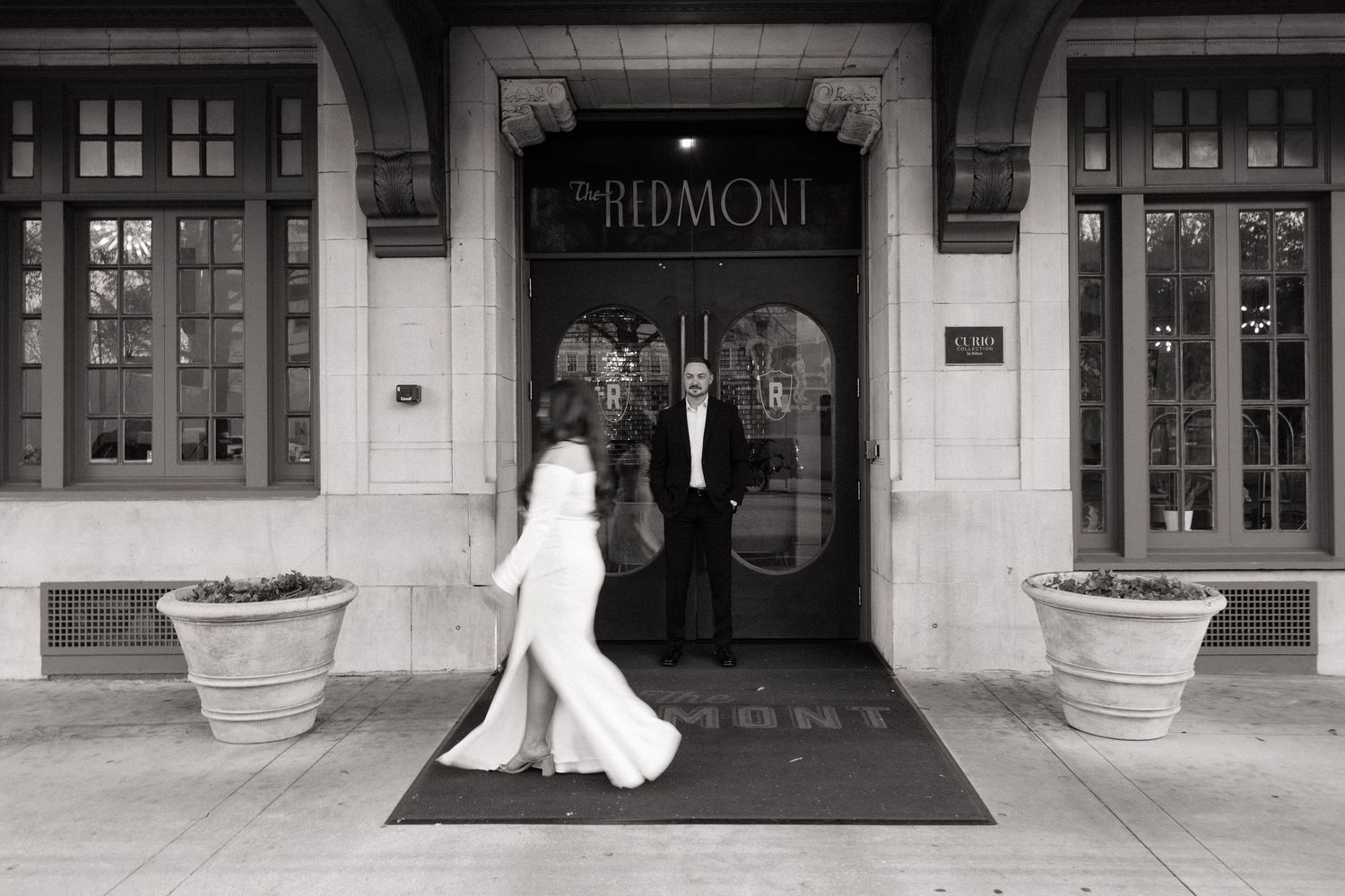 Couple posing in front of a historic building entrance.