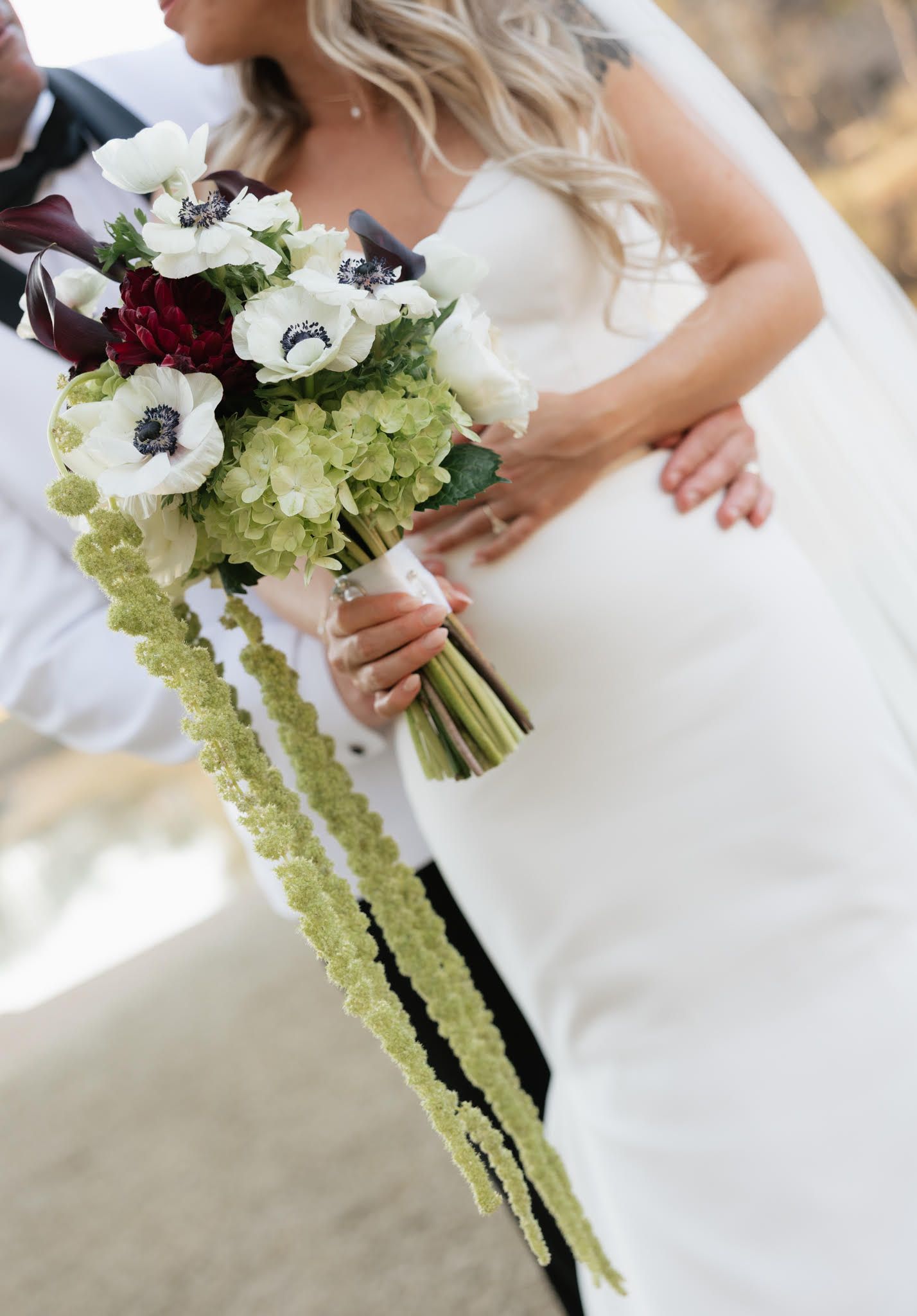 Elegant bridal bouquet featuring white flowers and cascading green amaranthus.
