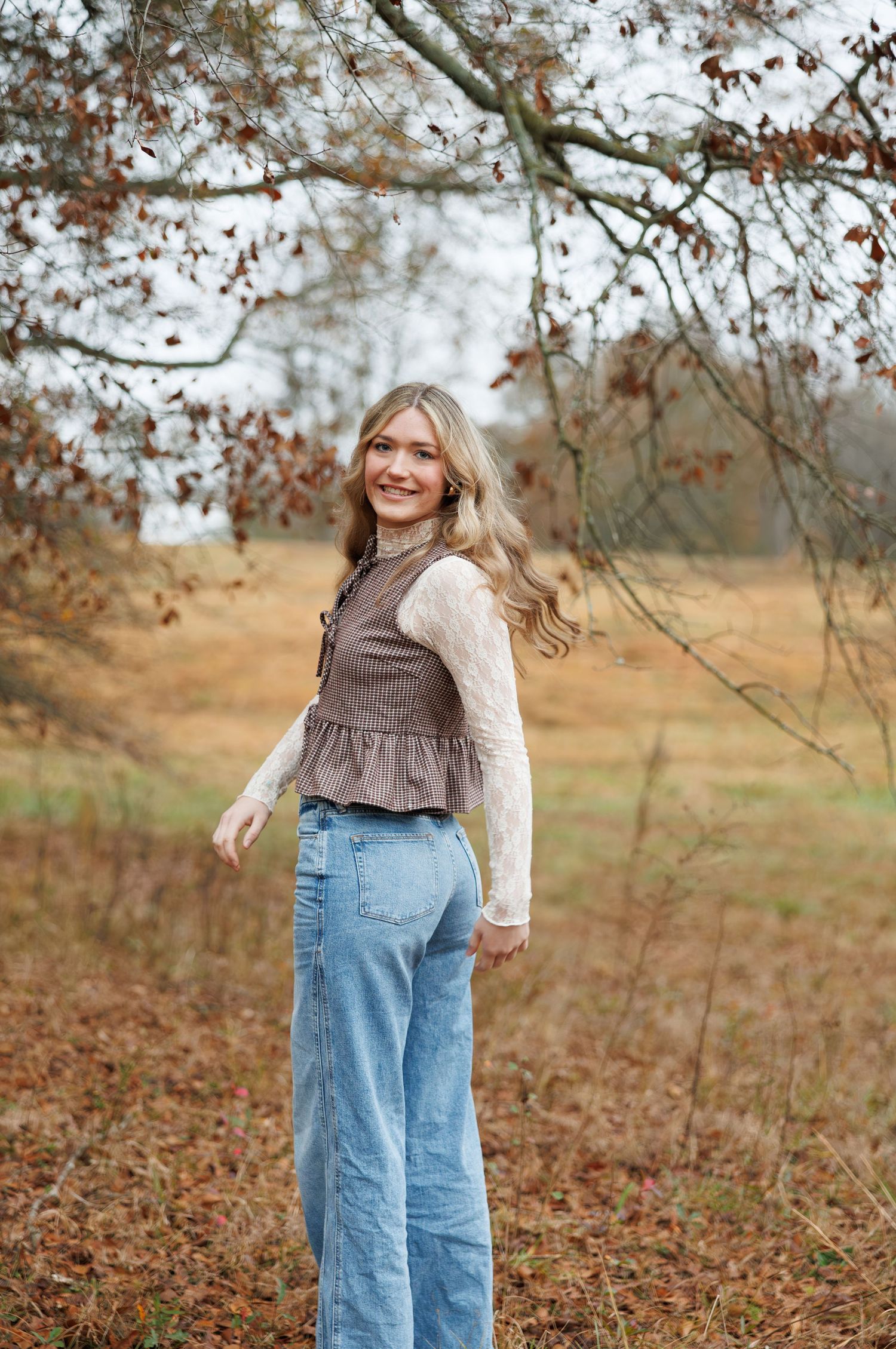 Casual outdoor portrait among fall foliage wearing vintage-inspired outfit.