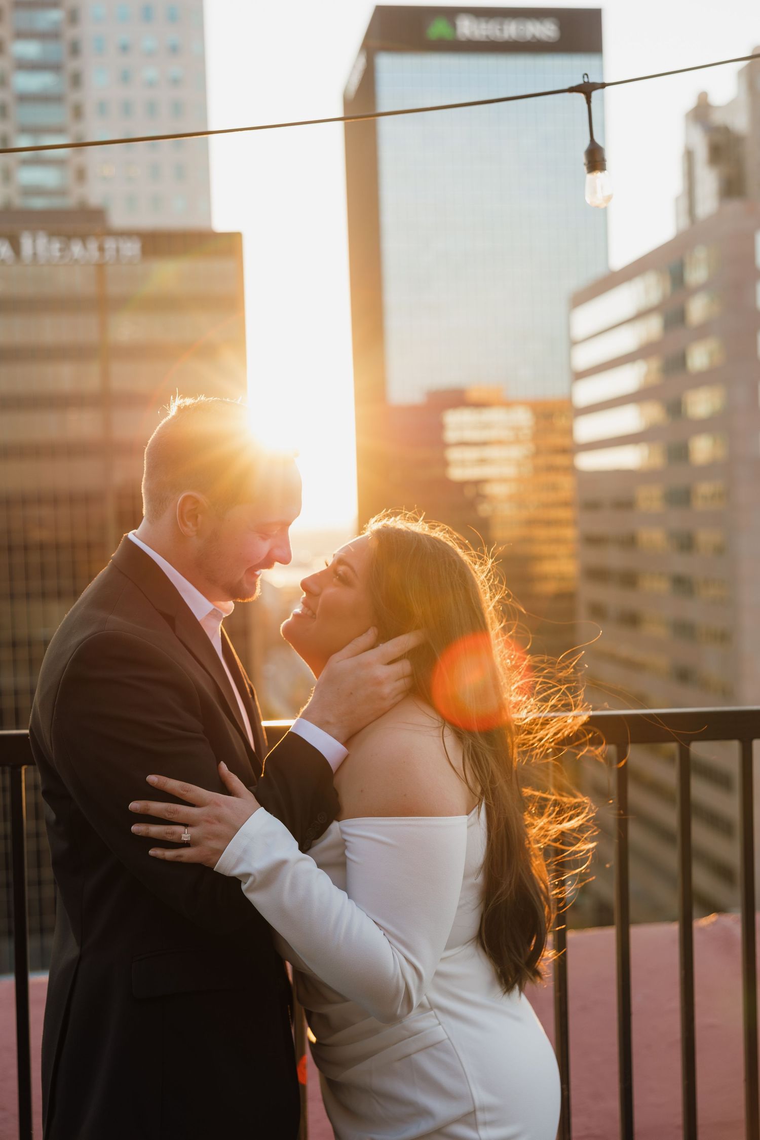 Couple sharing an intimate moment on a city rooftop at sunset.