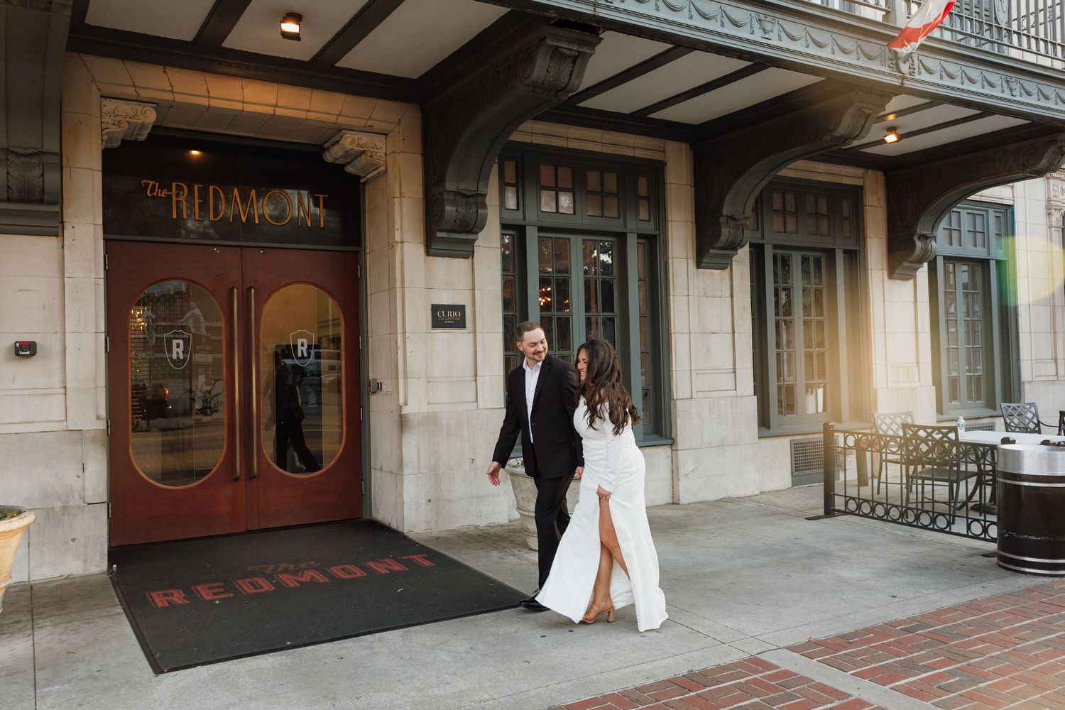 Couple entering the historic Redmont Hotel through ornate wooden doors.